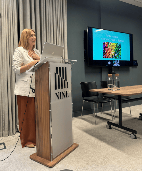 Lindsey Whitaker presenting on perimenopause nutrition at a corporate wellness event, highlighting science-led strategies to support midlife women in the workplace.