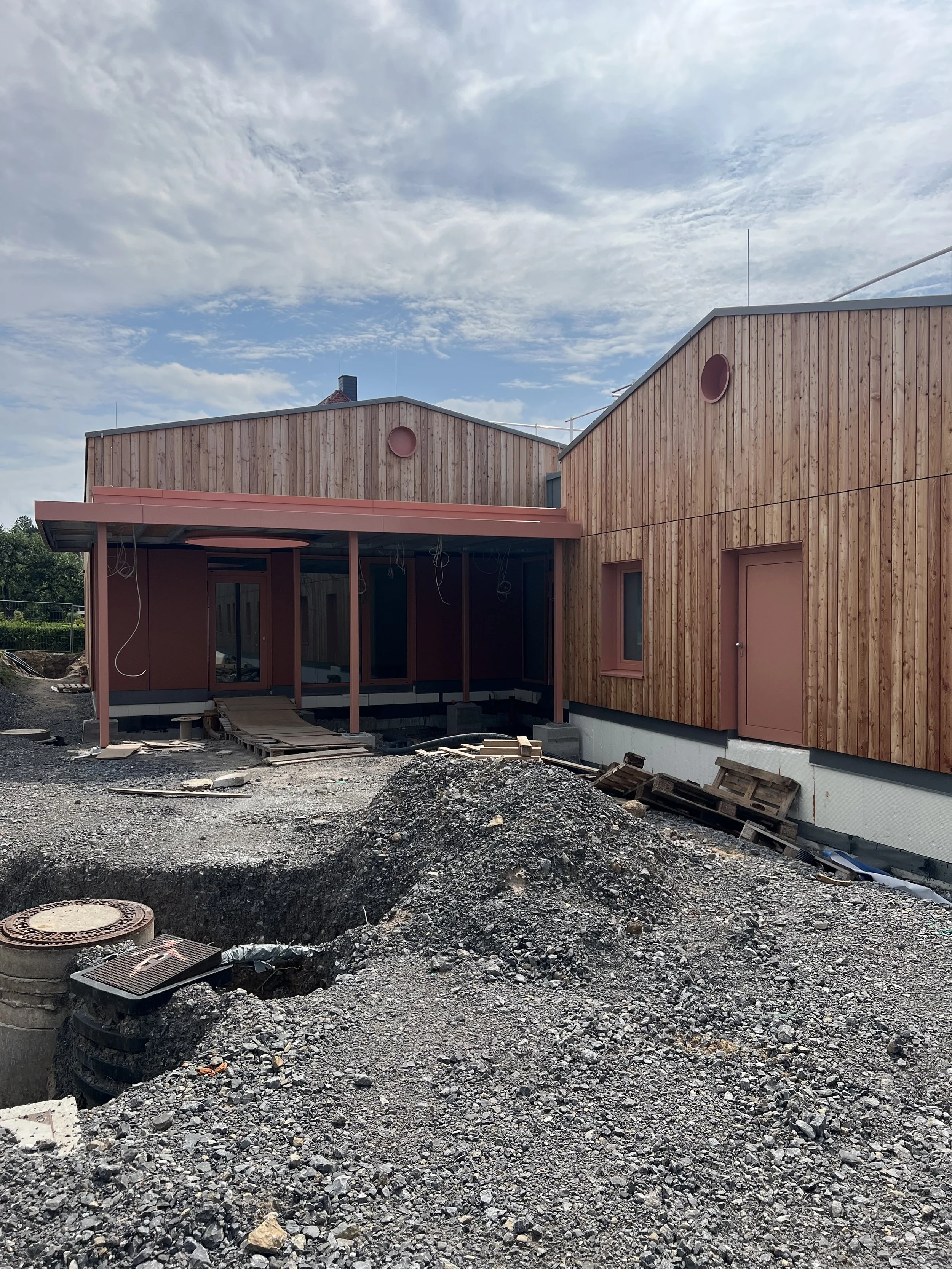 Der Bau einer modernen Holzhaus bauen, auf der Baustelle mit Erdmassen und Baumaterialien