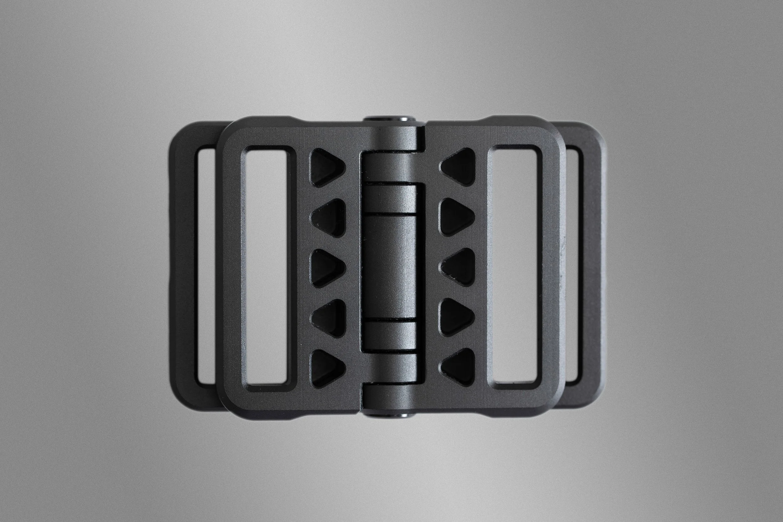 A black metal camera shoulder rig or stabilizer with adjustable parts, viewed from above against a gray background.