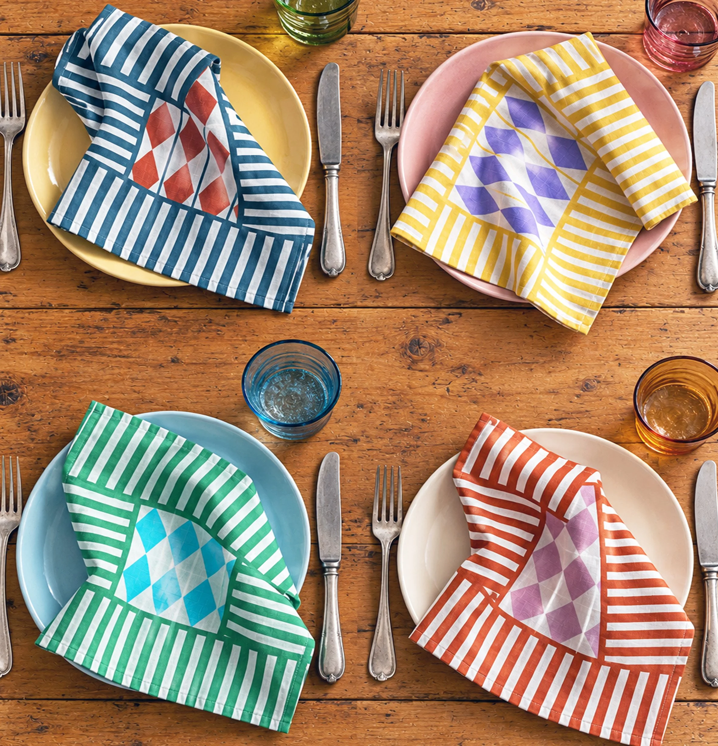 Set of four brightly coloured linen napkins in a diamond and stripe pattern