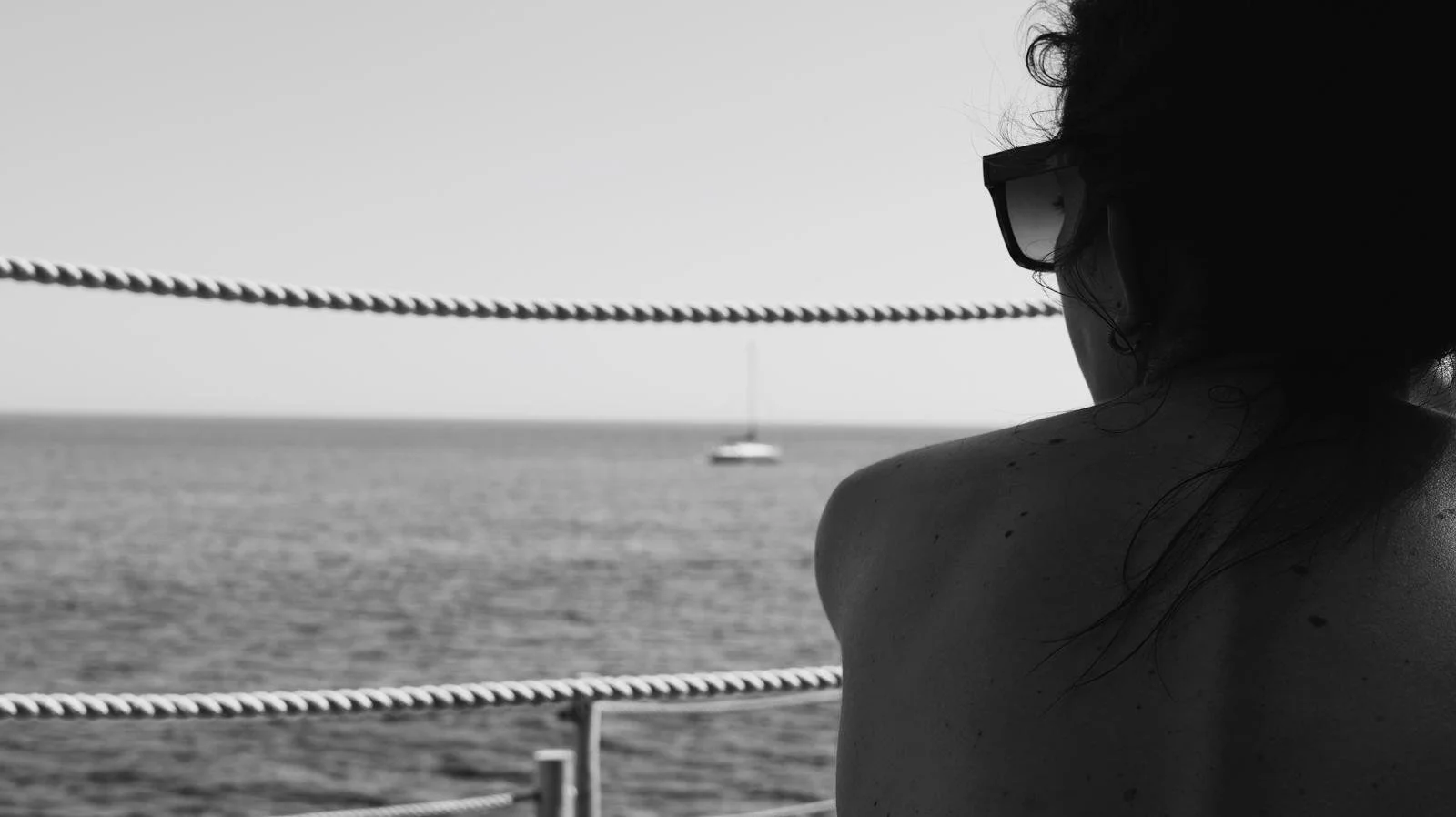 Woman with glases looking at the sea with boats