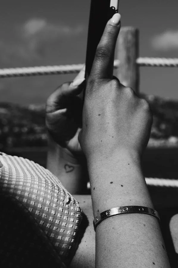 woman with tattoo holding smartphone in bikini