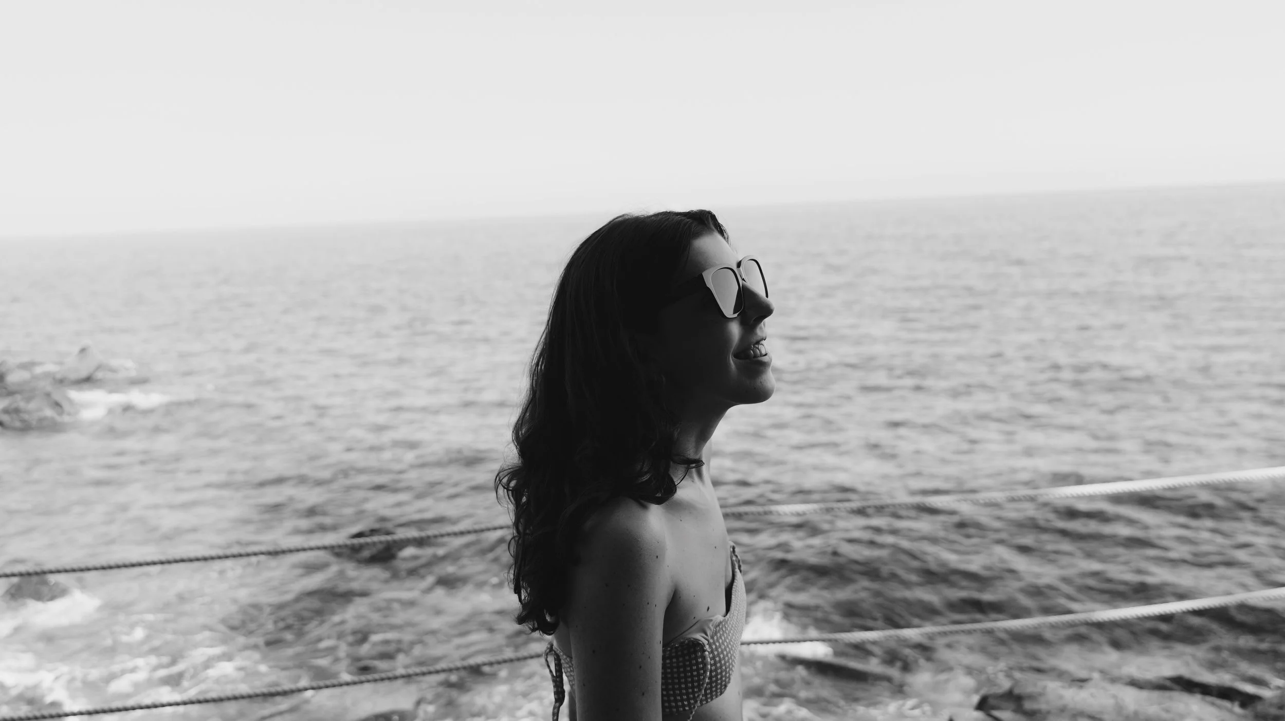 Woman at the sea smiling with glases