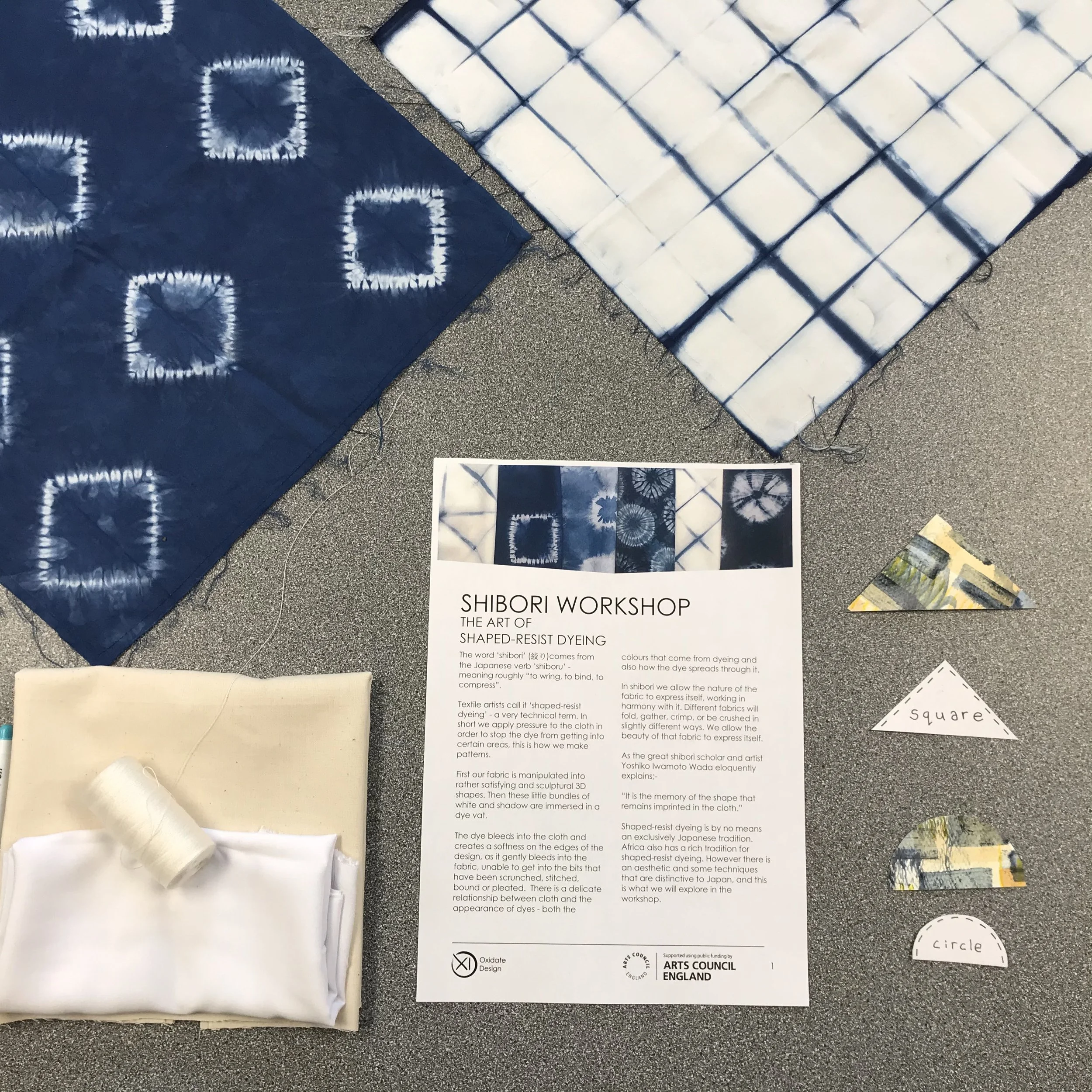 Display of tie-dye fabric samples, a printed sign for a shibori workshop, and paper pattern templates with shapes labeled circle and square.