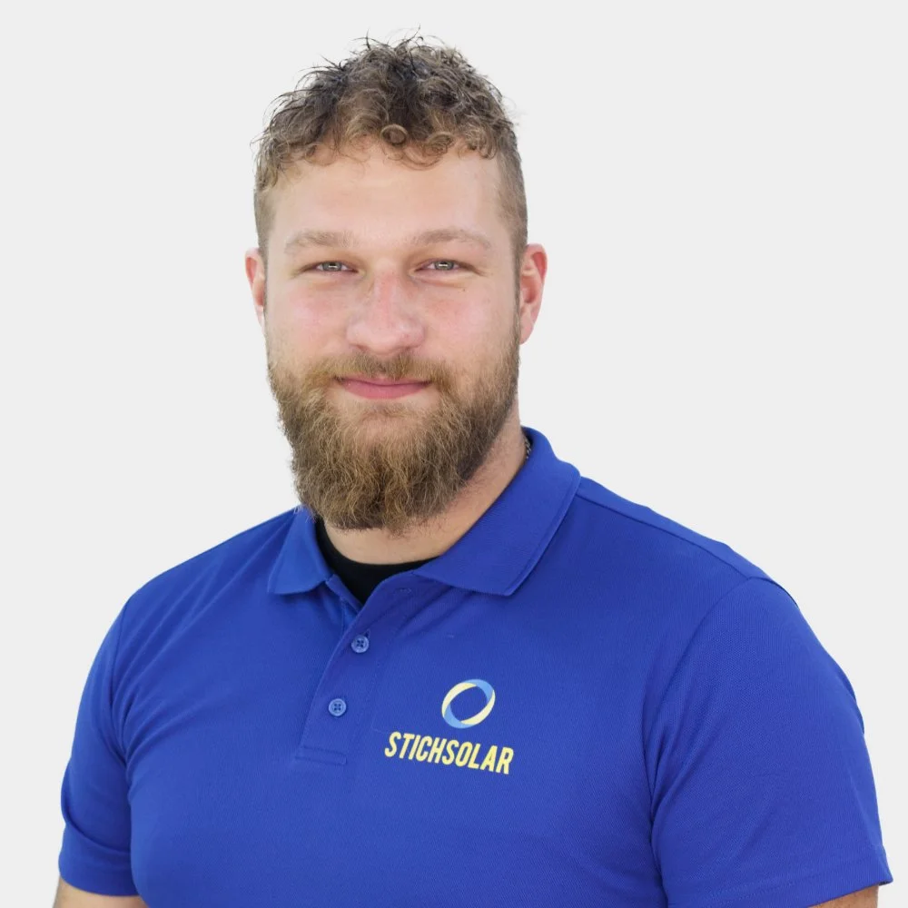 Mann trägt rote Polo-Shirt mit dem Logo 'Stichslar' auf der linken Brustseite, hat kurze dunkle Haare und schaut direkt in die Kamera.