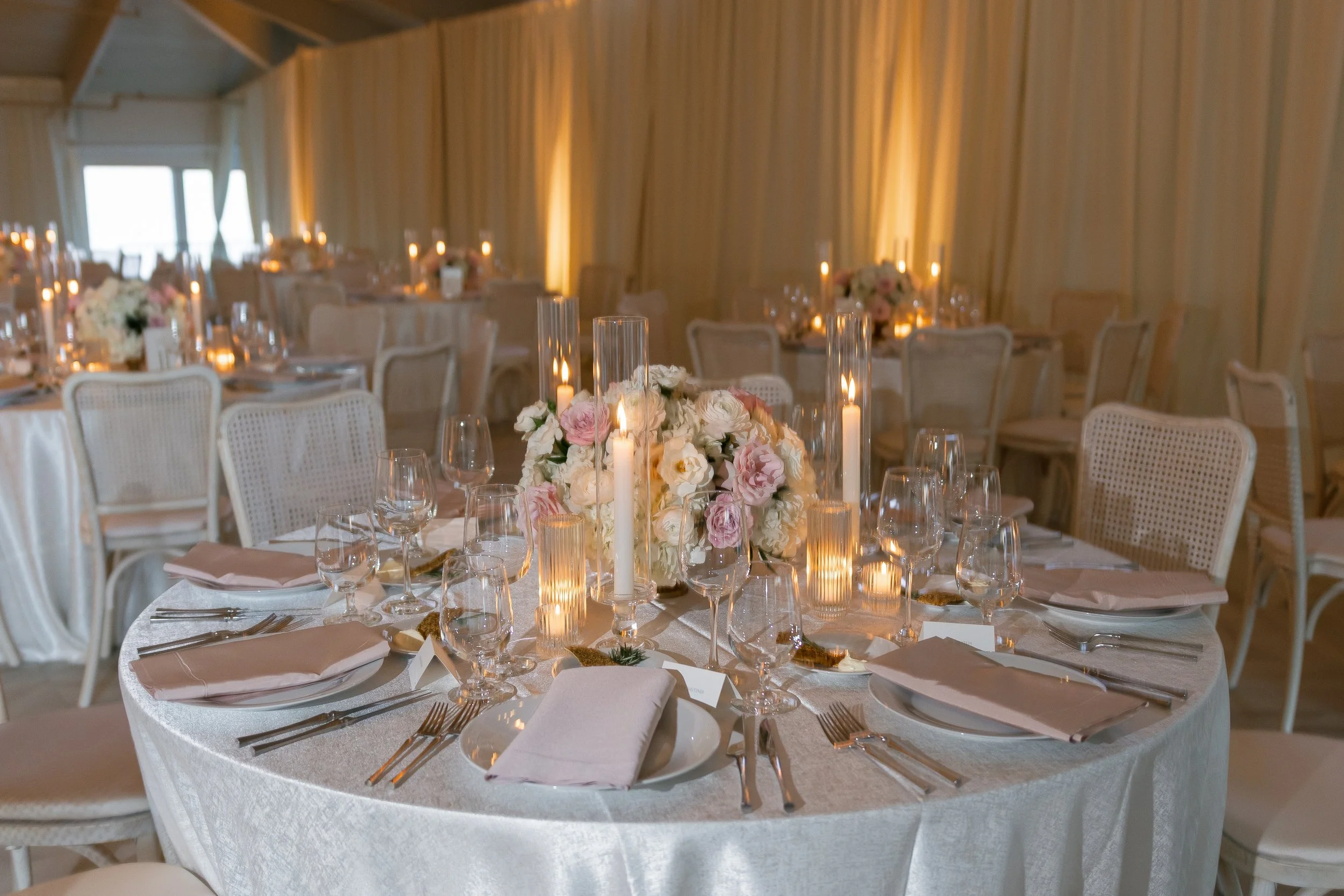 Indoor wedding reception set up, with formal dining tables.