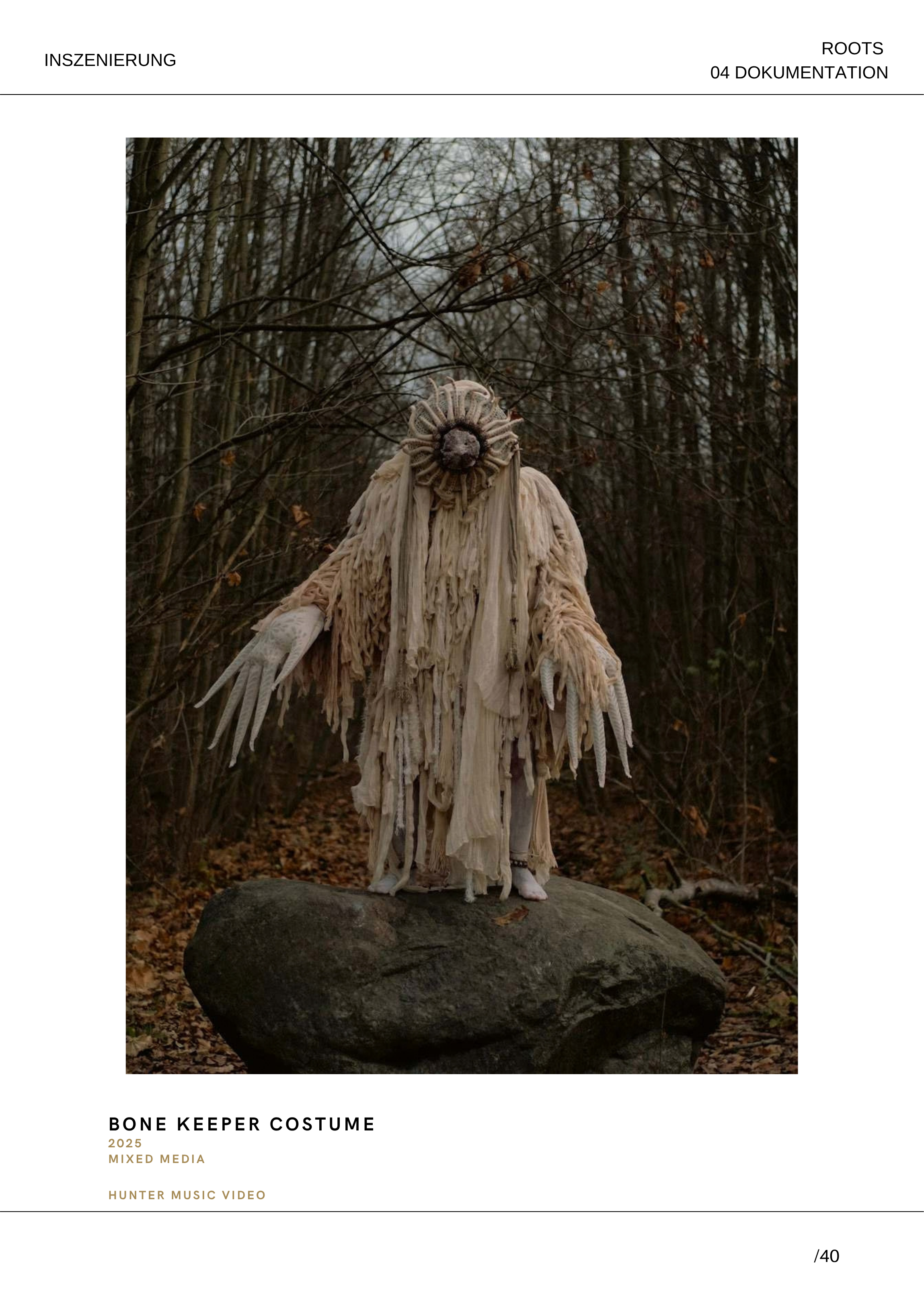Ein Mensch in einem Kostüm, das wie ein Totenkopf mit Zacken aussieht, steht auf einem großen Stein im Wald, umgeben von Bäumen und Laub auf dem Boden, während die Jahreszeit vermutlich Herbst oder Winter ist.