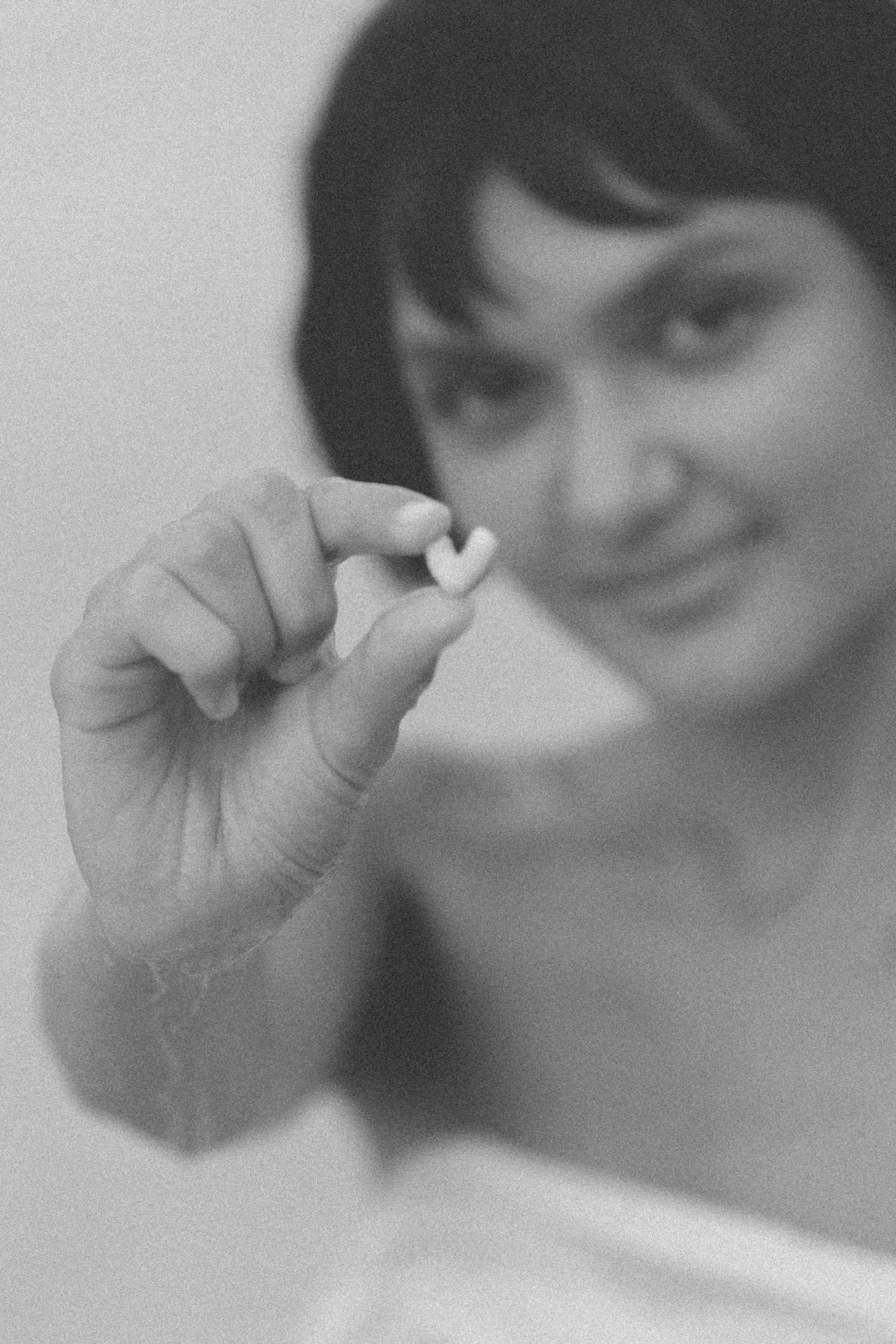black and white photo of a woman holding a heart shaped rock on the beach