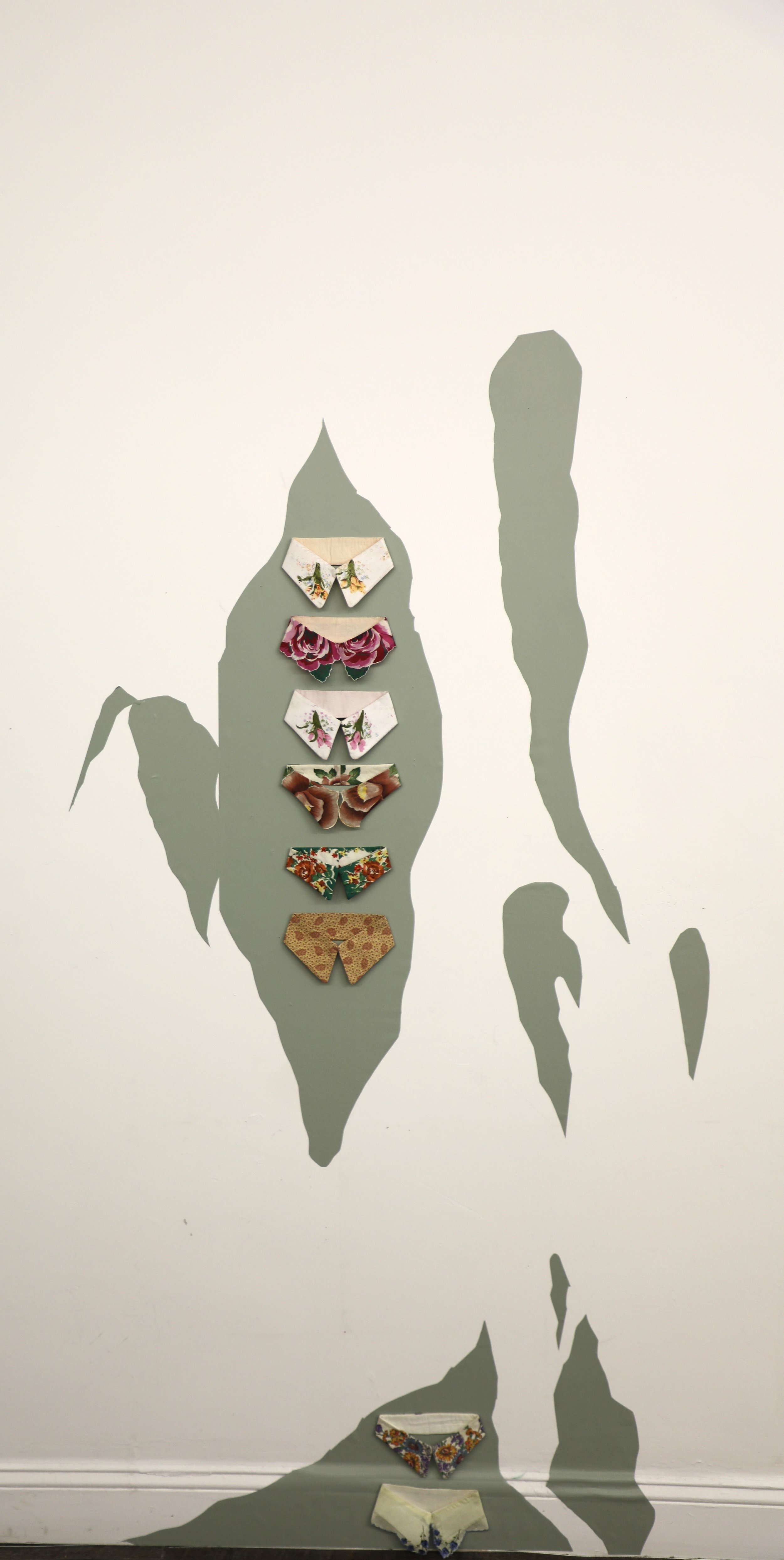 Collars (installation view), 2025, reused textile, wallpaper, 48" x 60"