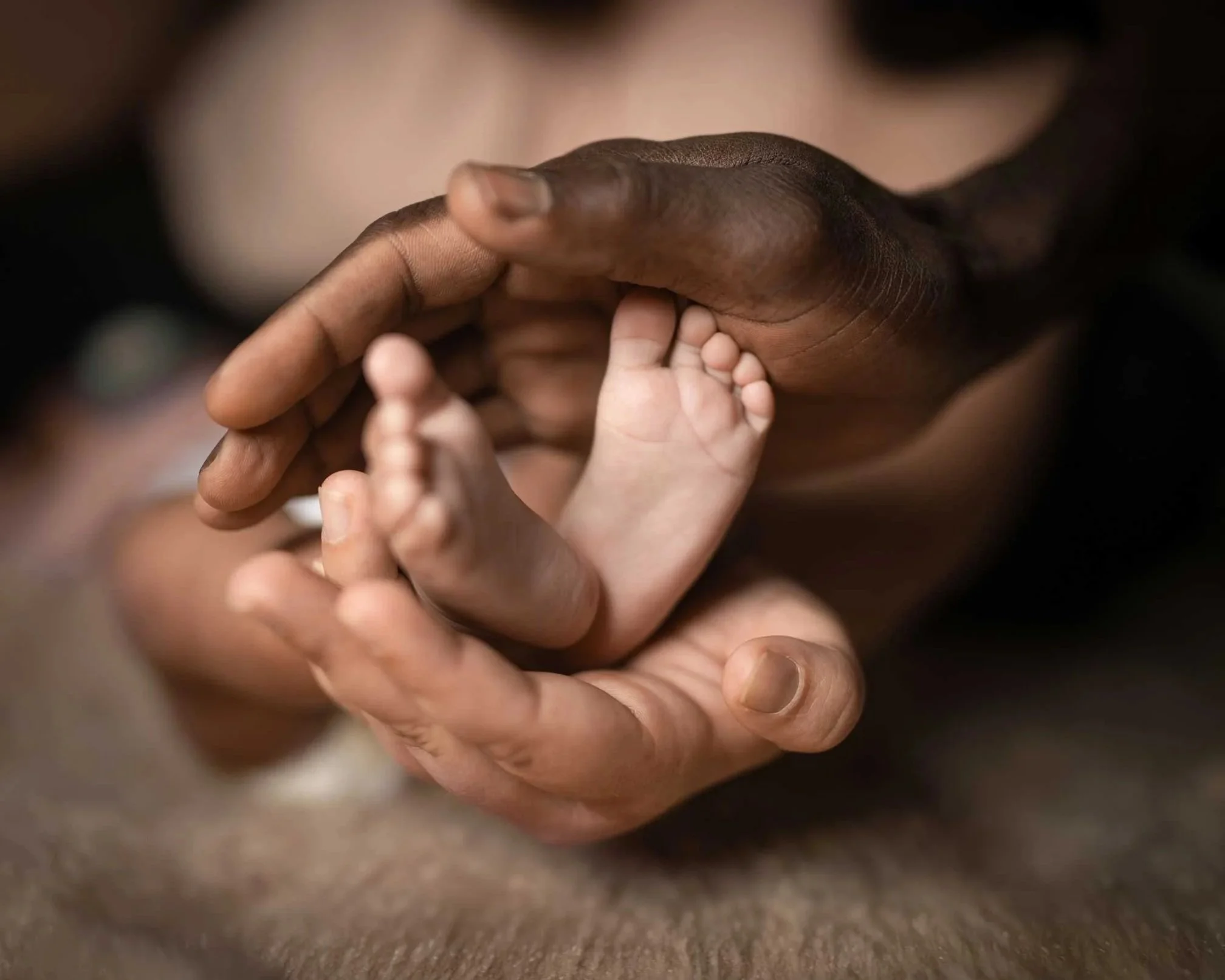 BIPOC-Parent-hands-holding-baby-feet.jpg