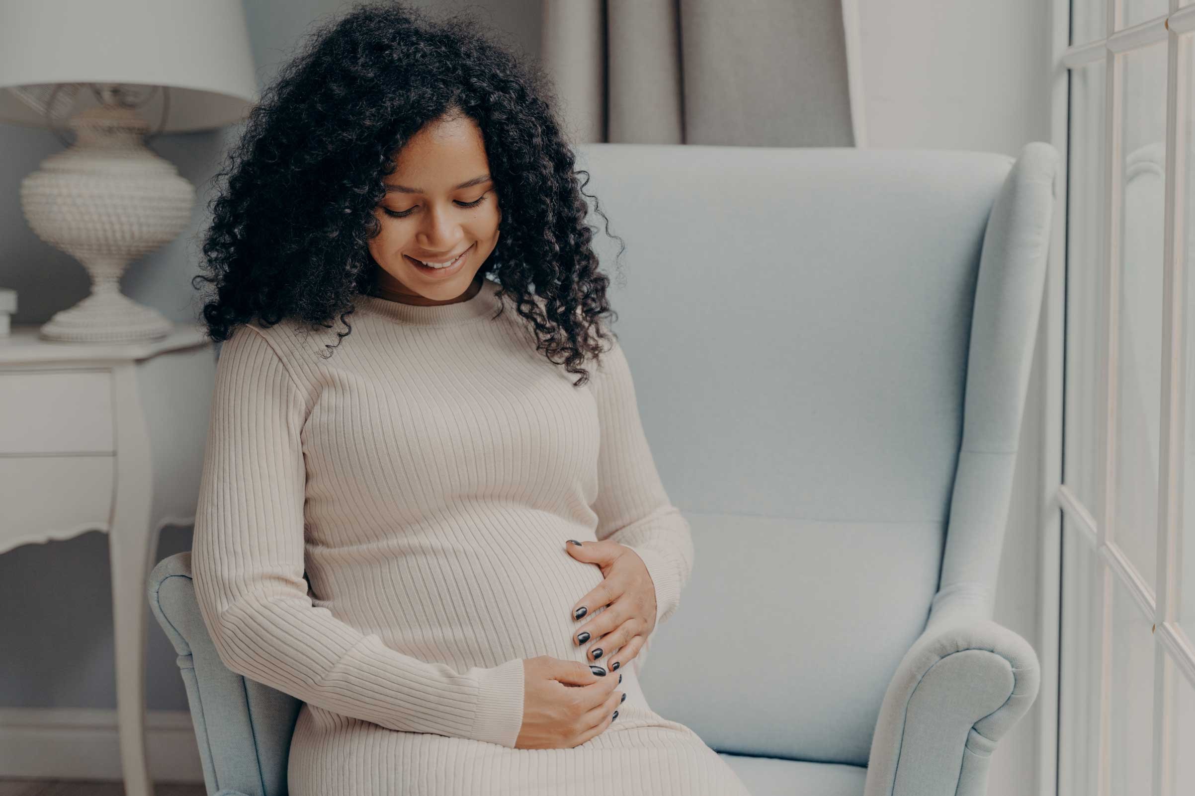 Pregnant-Woman happily holding her belly