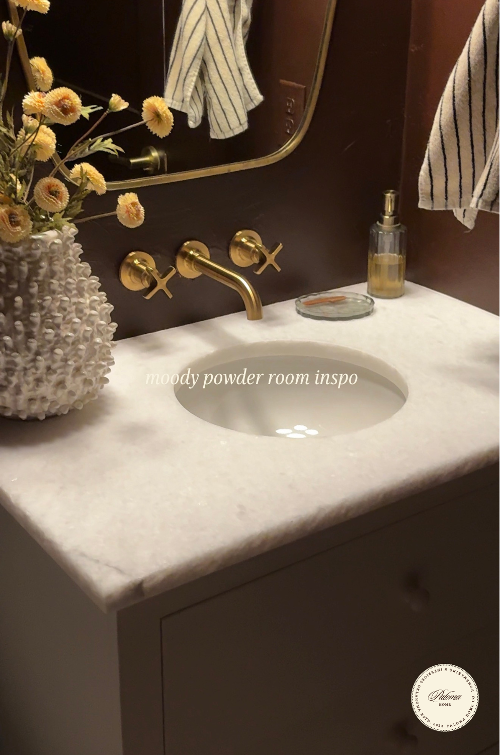 a moody, rich maroon powder room with brass accents