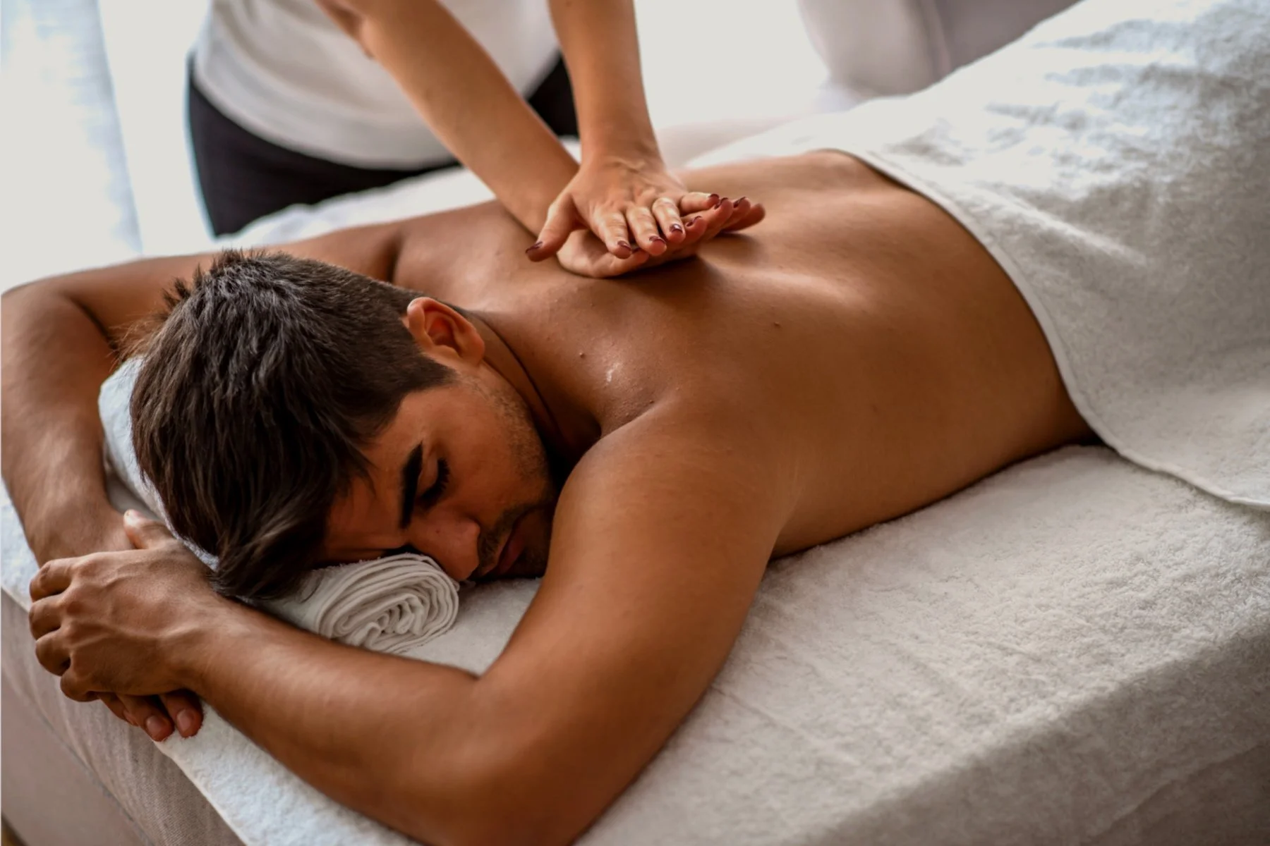 An esthetician at VIP Esthetics & Hair performing a relaxing full-body massage on a client, using expert techniques to relieve tension and promote relaxation in a tranquil spa setting.