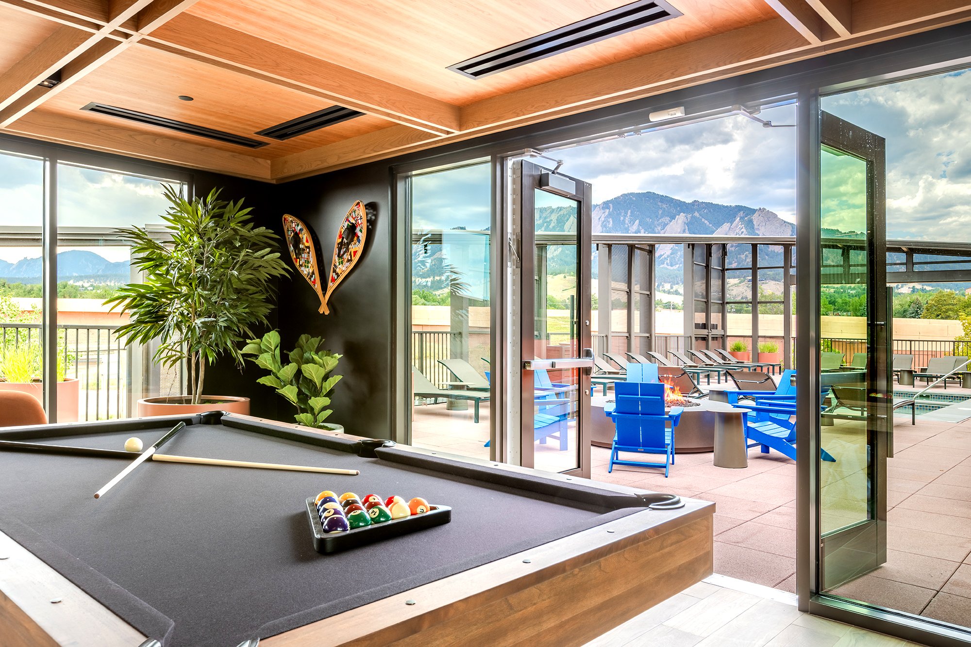 HUB 28th Street amenity lounge featuring floor-to-ceiling windows, colorful furnishings, and contemporary interior finishes.