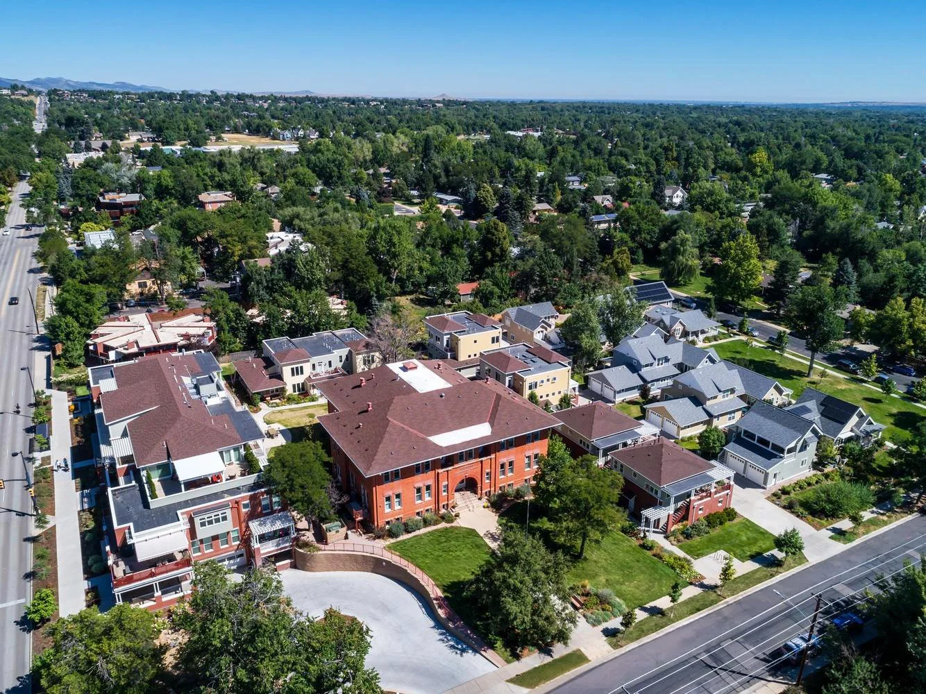 Aerial view of Washington Village in Boulder, Colorado, showing the preserved historic school building, courtyard, and surrounding residential neighborhood.