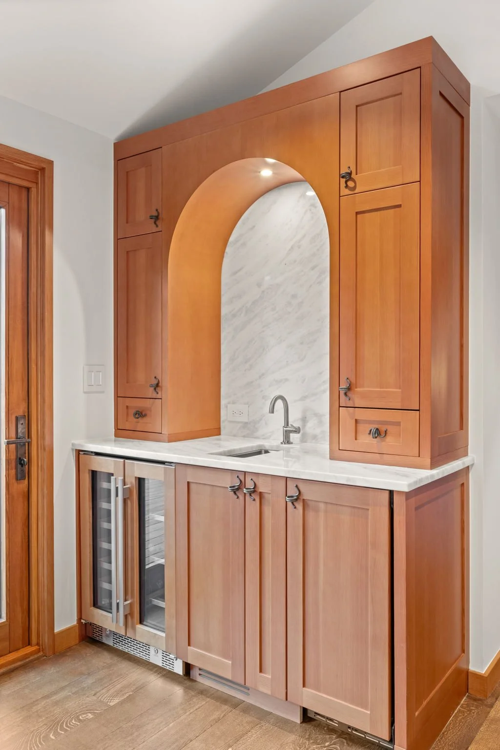 Kitchen bar at the Cedar & Stone residence in Jefferson County, Colorado, with wood cabinetry, marble countertop, and built-in wine cooler.