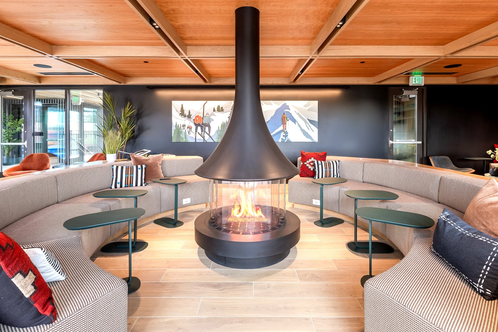 HUB 28th Street rooftop lounge featuring a central fire pit, contemporary seating, wood ceiling, and mountain views.