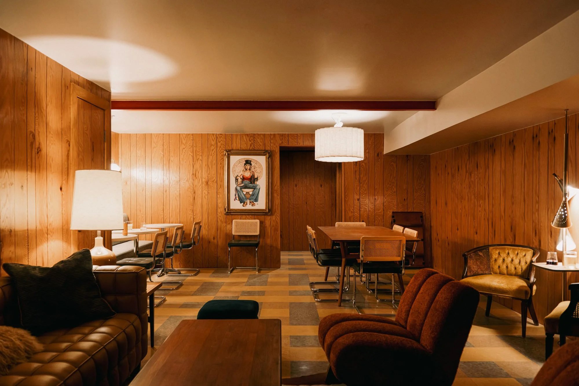 Communal or meeting space at La Vista Motel in Denver, CO with seating and wood-paneled walls.