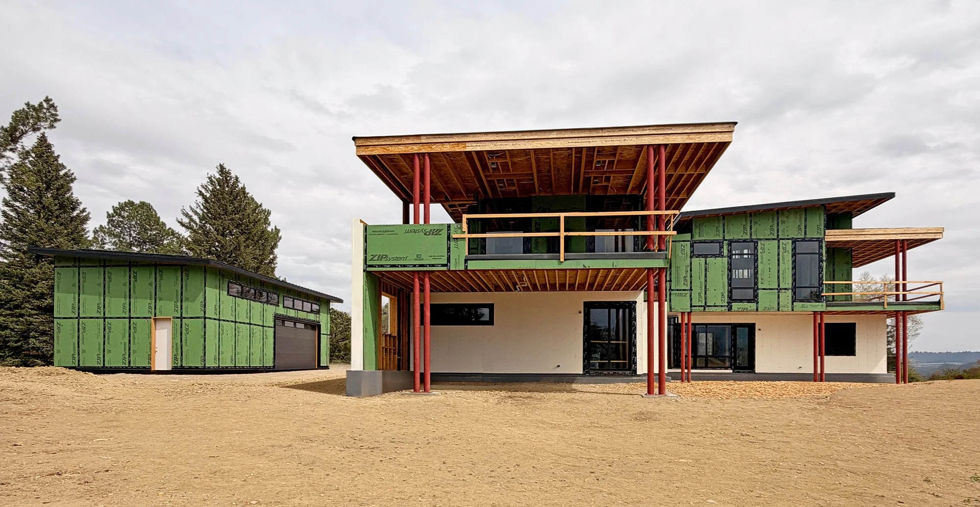 Rear elevation of a contemporary home under construction with steel supports and large cantilevered roof structure in Boulder County Colorado -Designed by Sopher Sparn Architects 