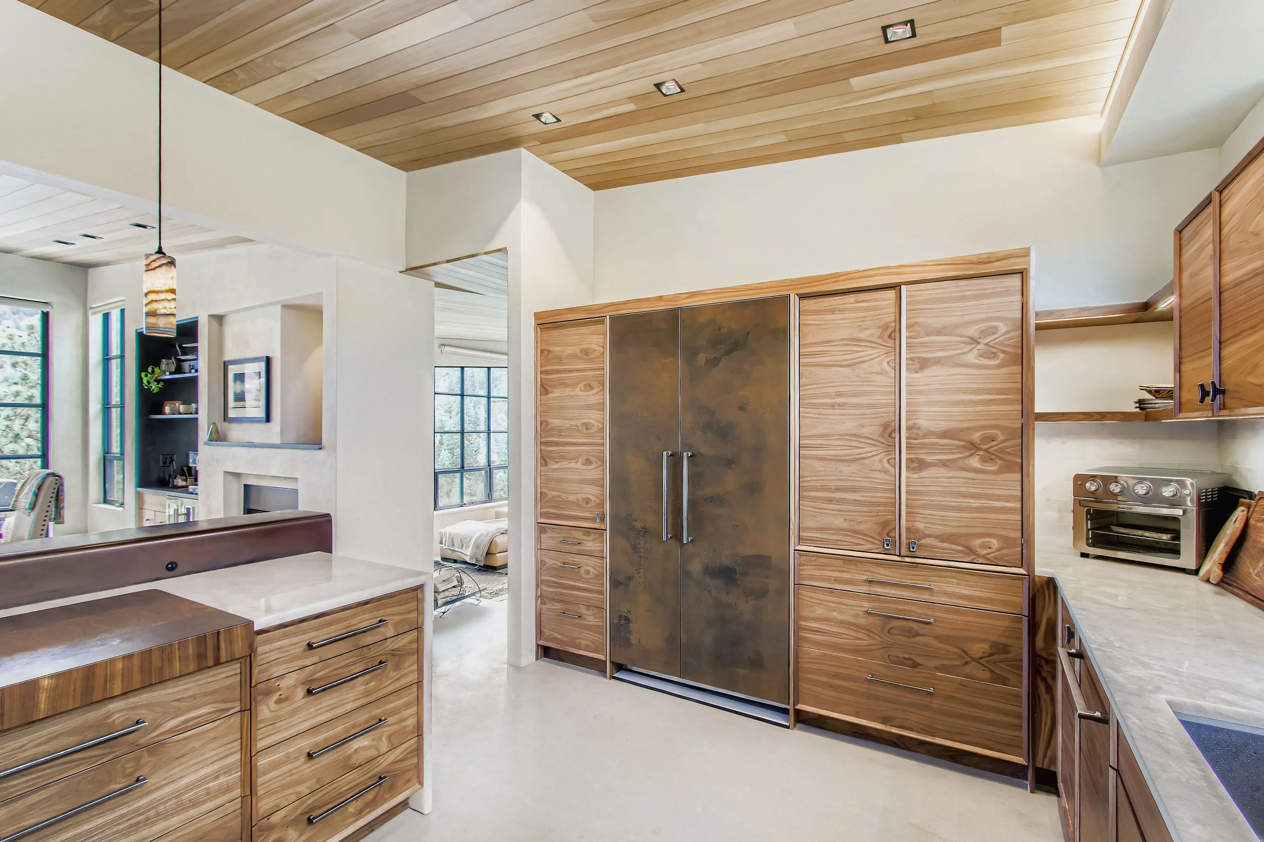 Kitchen at Onyx Ridge, Boulder County, CO, with wooden cabinets and a large stainless steel refrigerator.