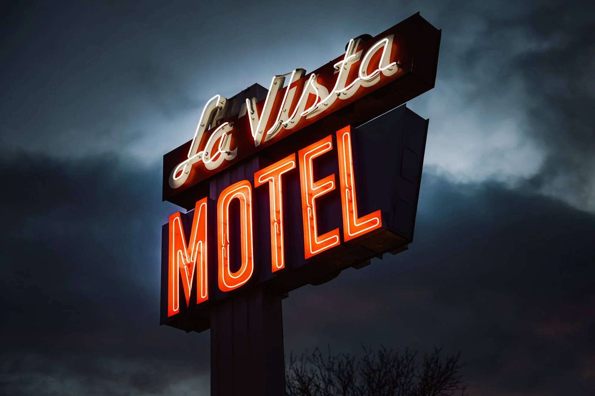 Exterior sign of La Vista Motel in Denver, CO illuminated at night under a dark sky.