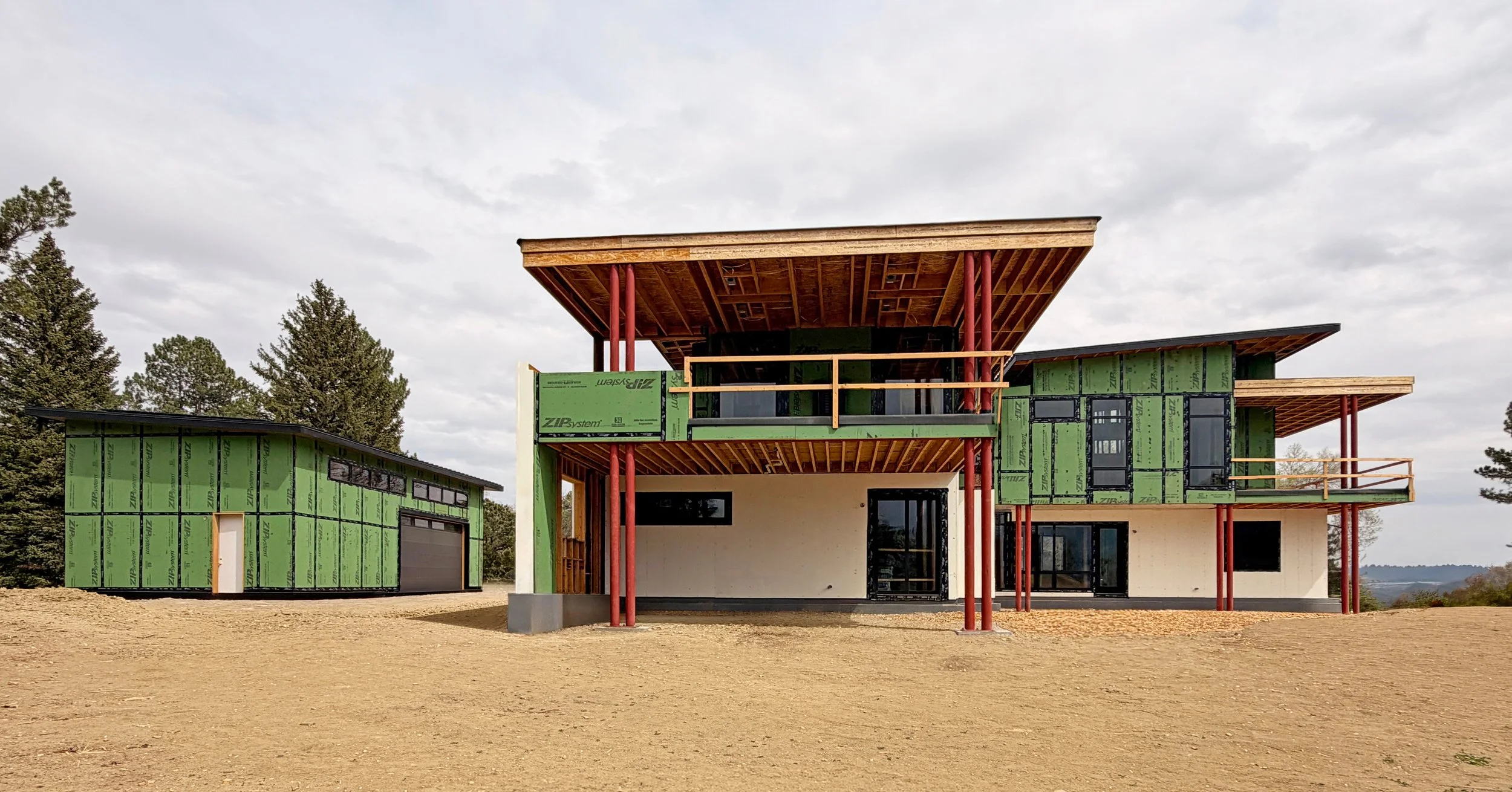 Rear elevation of a contemporary home under construction with steel supports and large cantilevered roof structure in Boulder County Colorado -Designed by Sopher Sparn Architects 