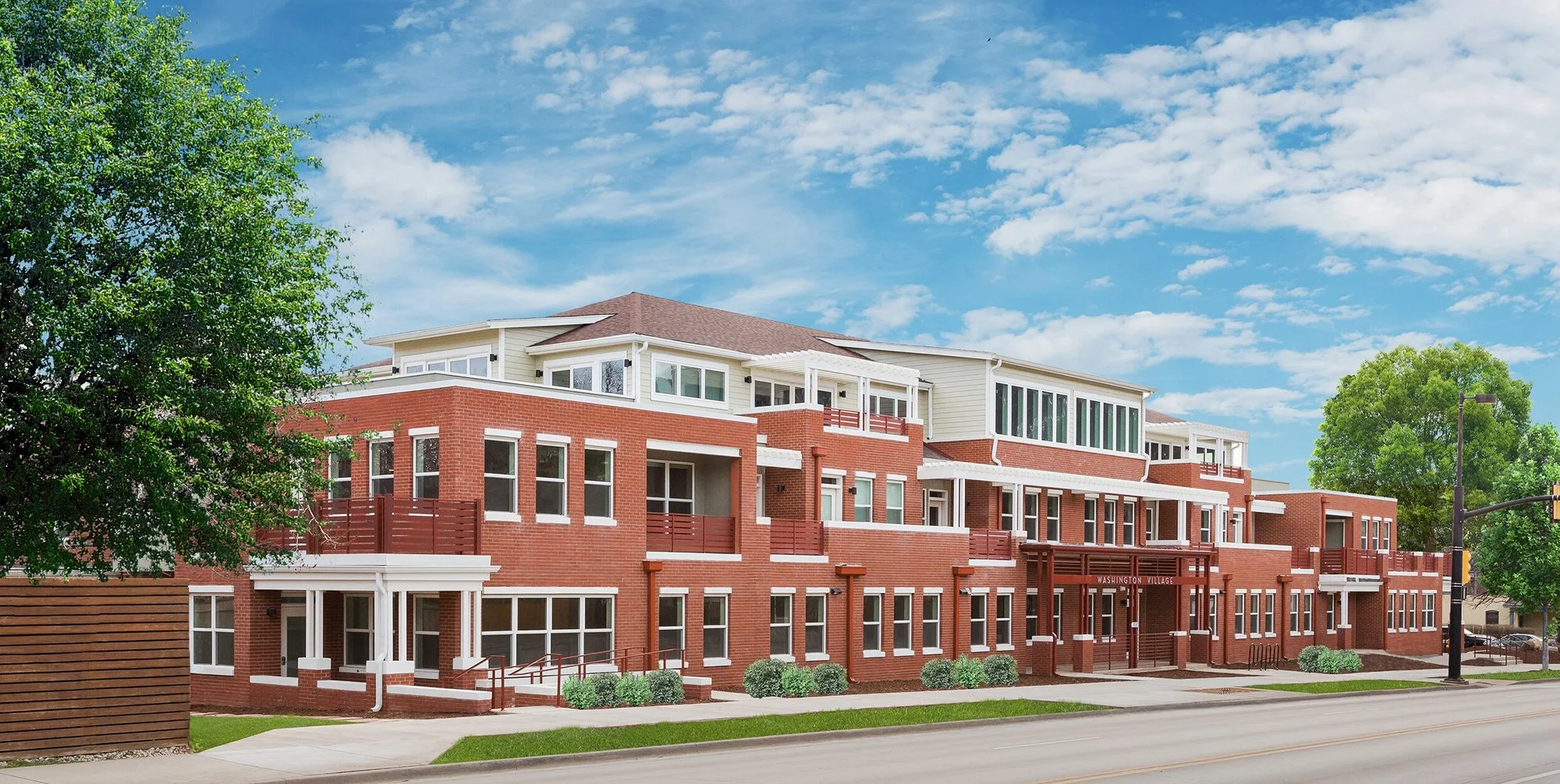 Washington Village residential building in Boulder, Colorado, featuring red brick architecture with balconies and street-facing entries. – Designed by Sopher Sparn Architects LLC