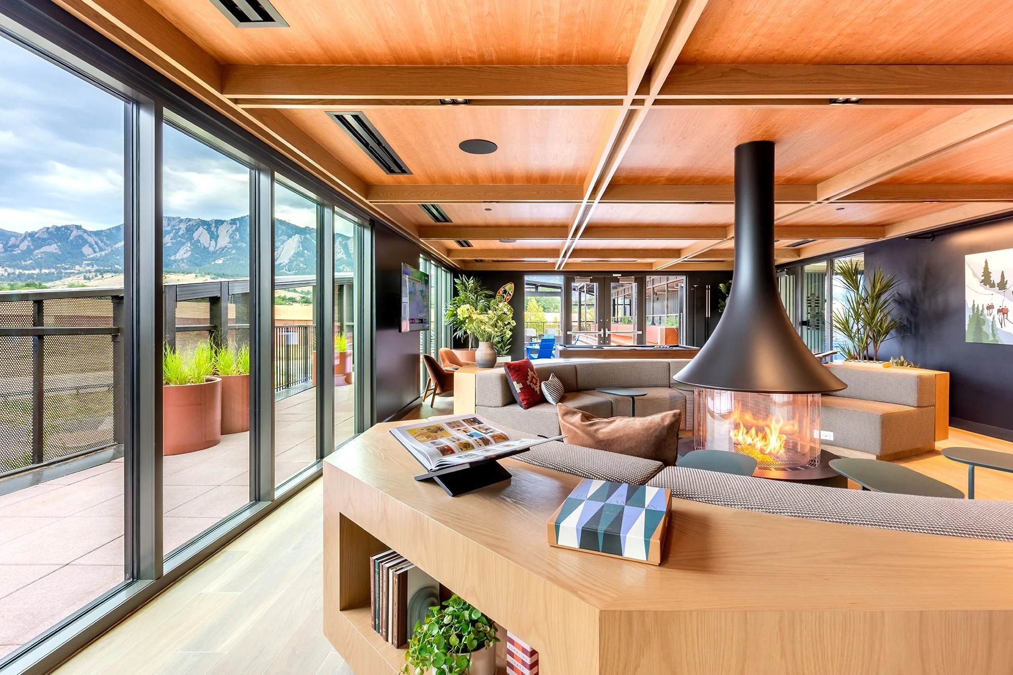 HUB 28th Street indoor-outdoor lounge with wood ceiling, comfortable seating, large windows, and access to the rooftop terrace.