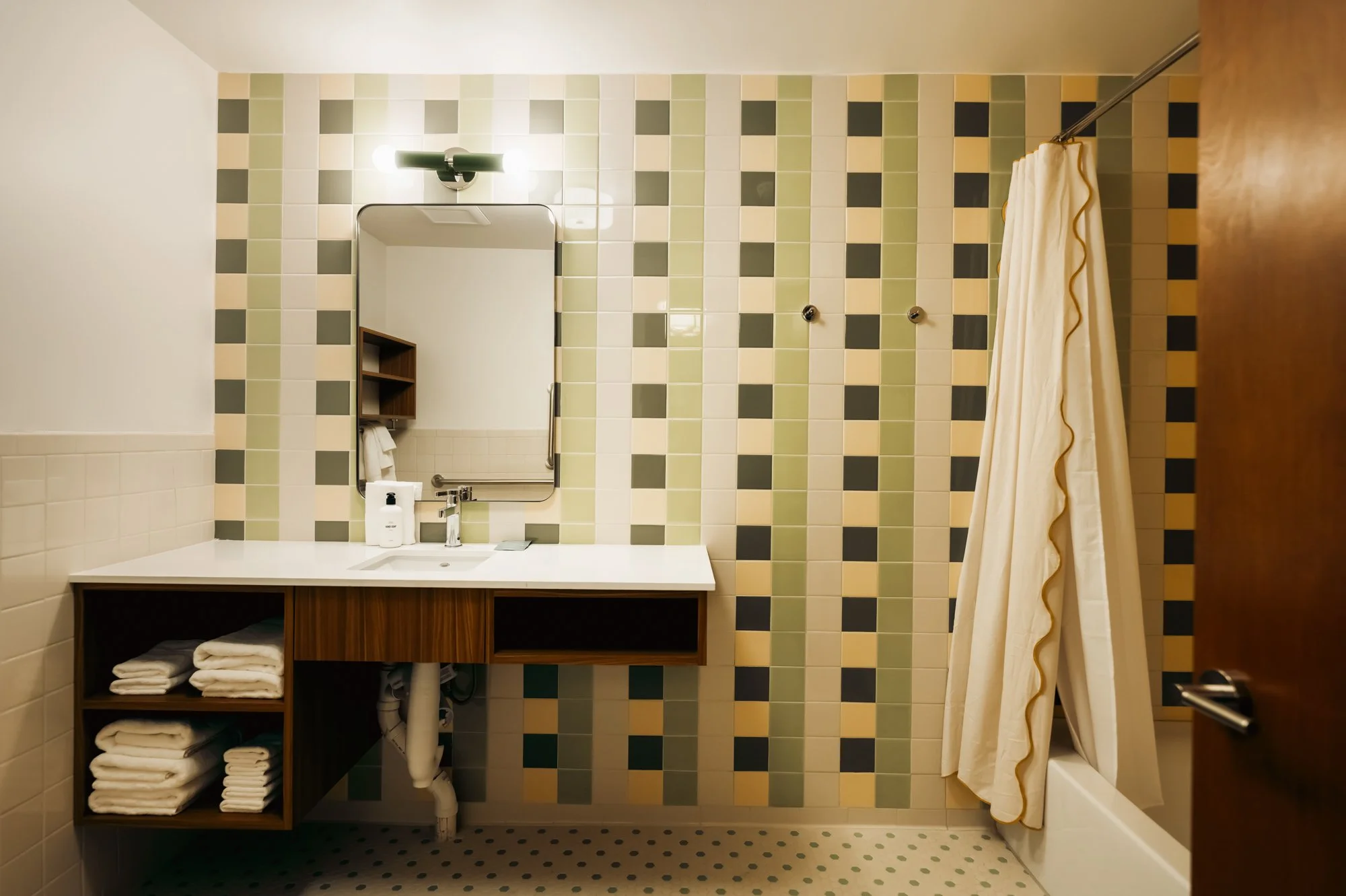 Bathroom at La Vista Motel in Denver, CO with sink, mirror, and contemporary tile design.