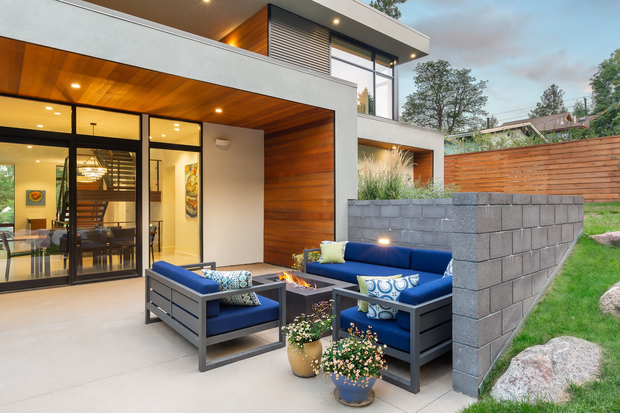 Outdoor patio at the Mod 7 residence in Boulder, Colorado, with lounge seating around a fire pit and large sliding glass doors.