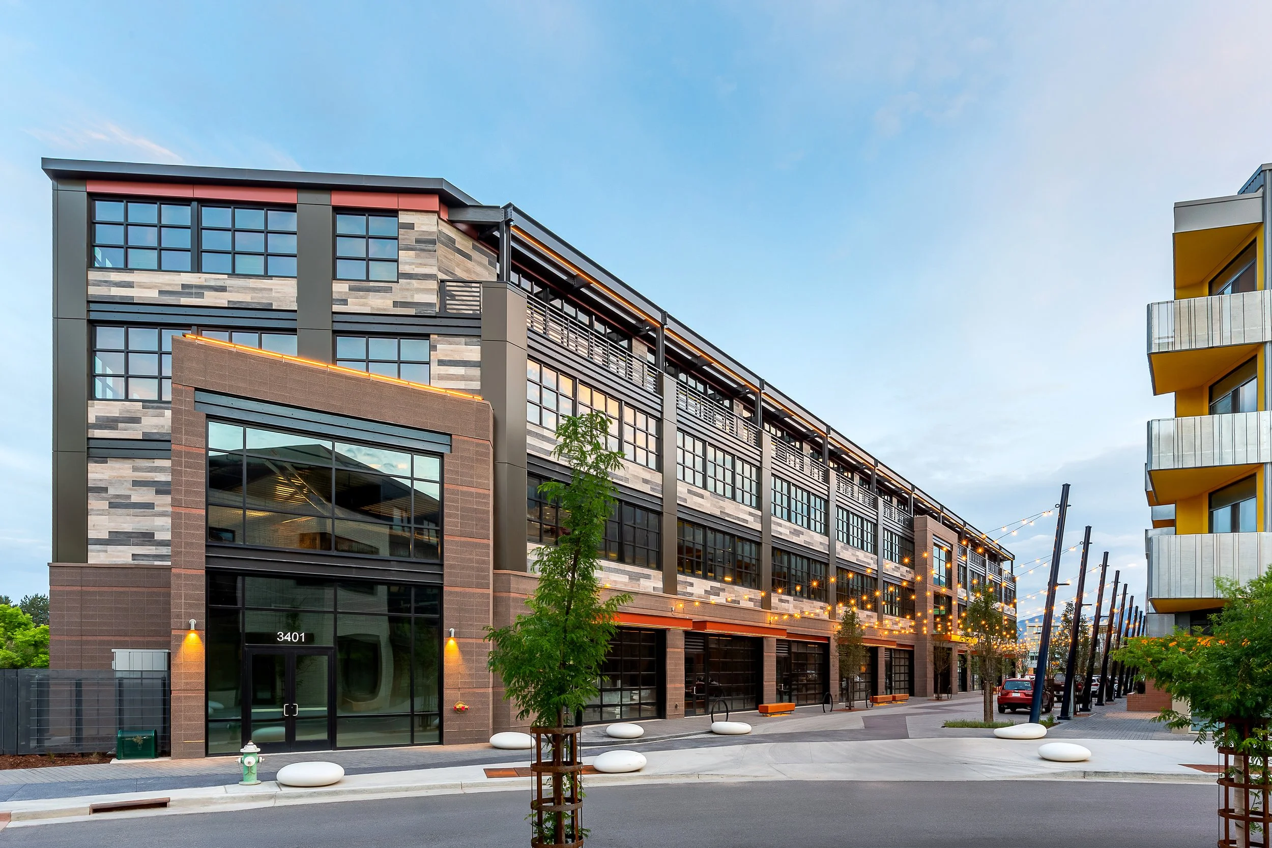 Exterior view of S’PARK Railyards with industrial-inspired design, factory-style windows, and pedestrian-friendly Woonerf in Boulder.