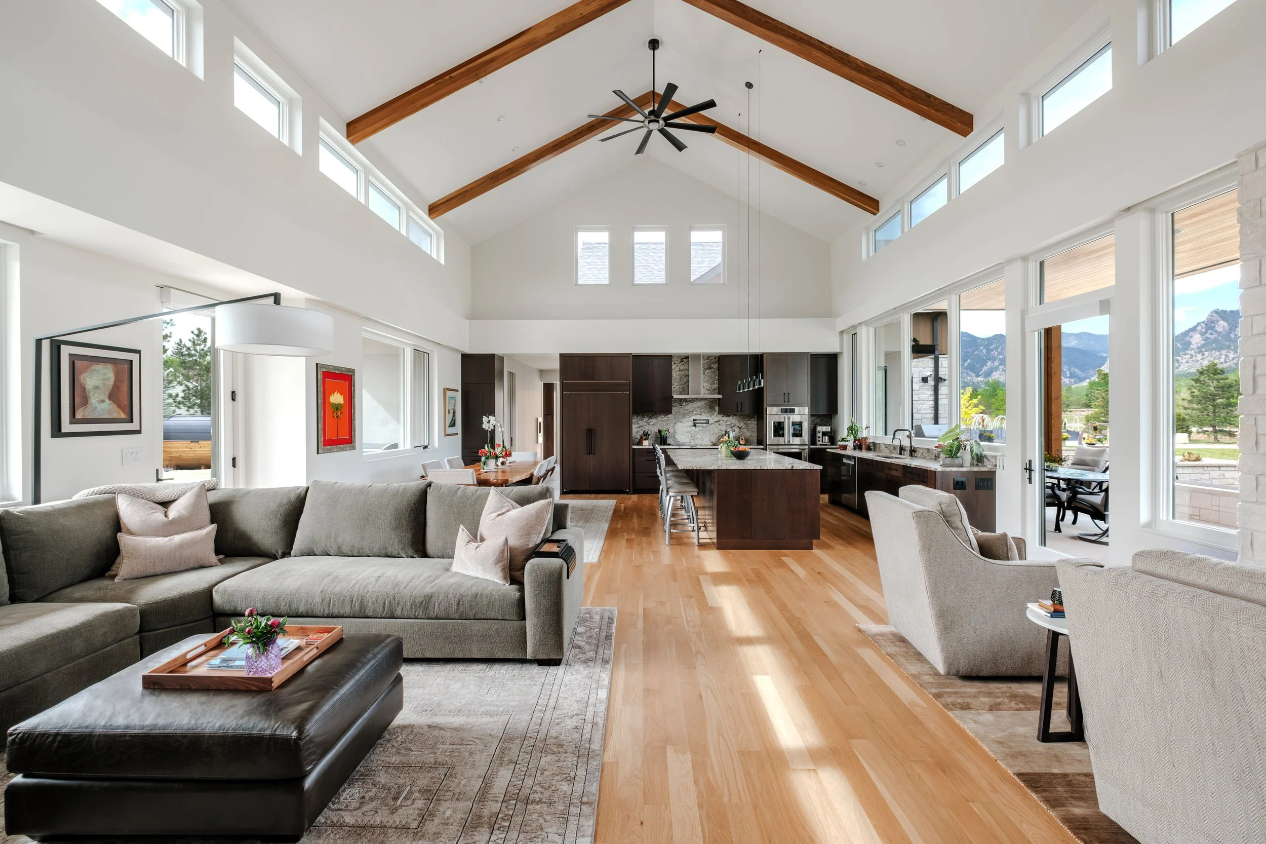 Contemporary kitchen and dining area with exposed wood beams, large island, and abundant natural light.