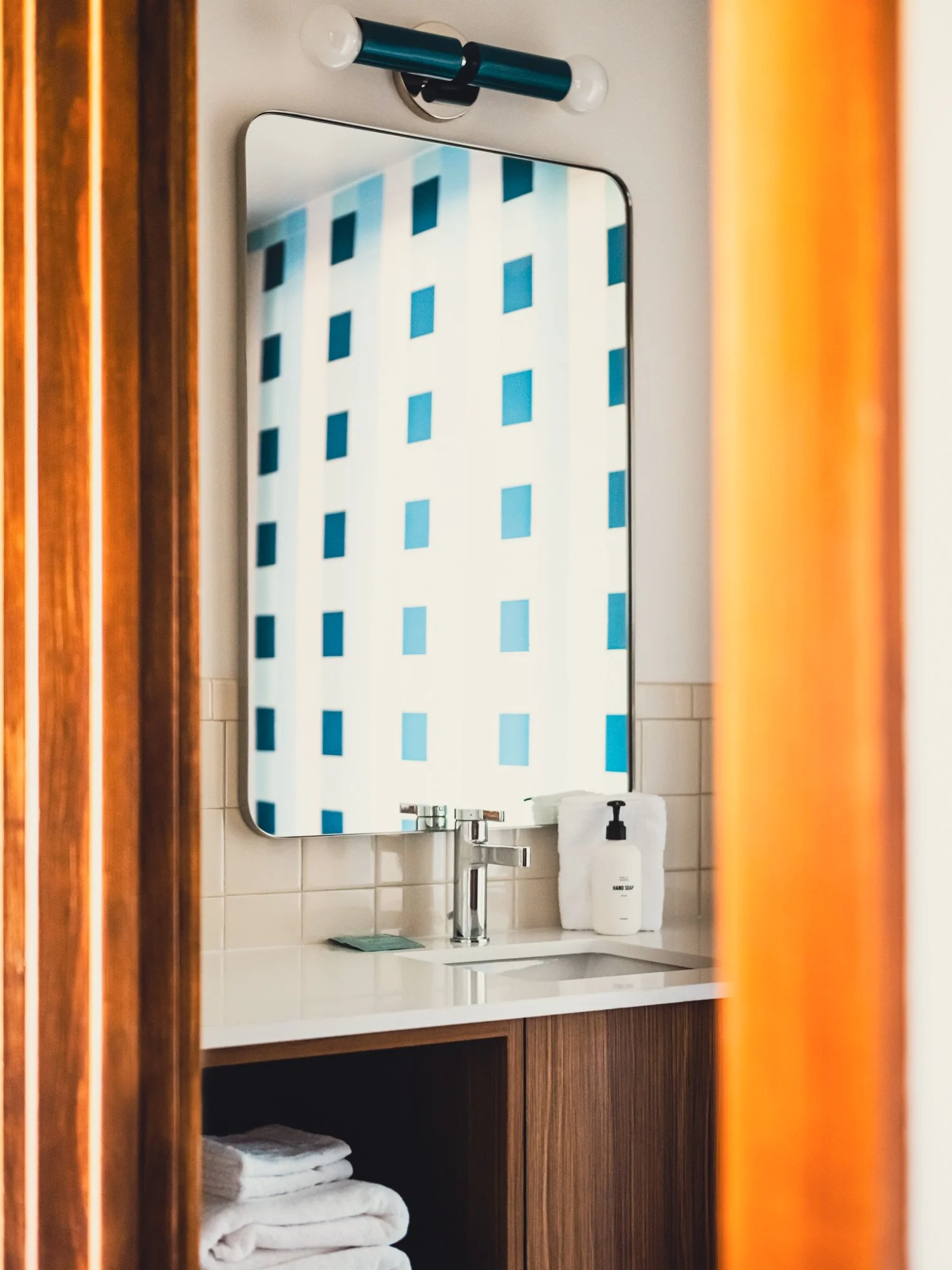 Bathroom interior at La Vista Motel in Denver, CO highlighting the sink, mirror, and modern design elements.