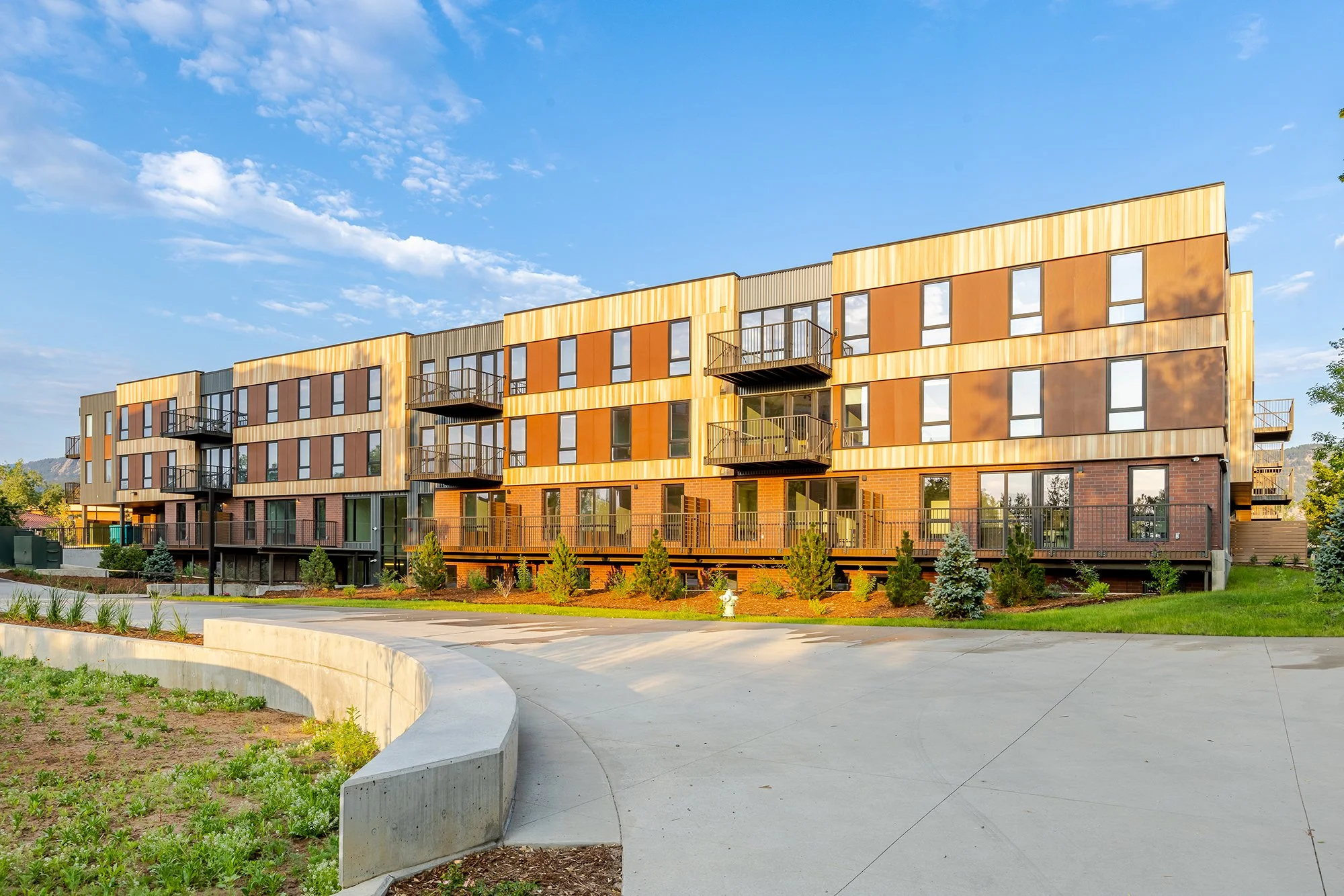 Wide exterior view of HUB 28th Street showing the multi-story residential building and landscaped pedestrian path.