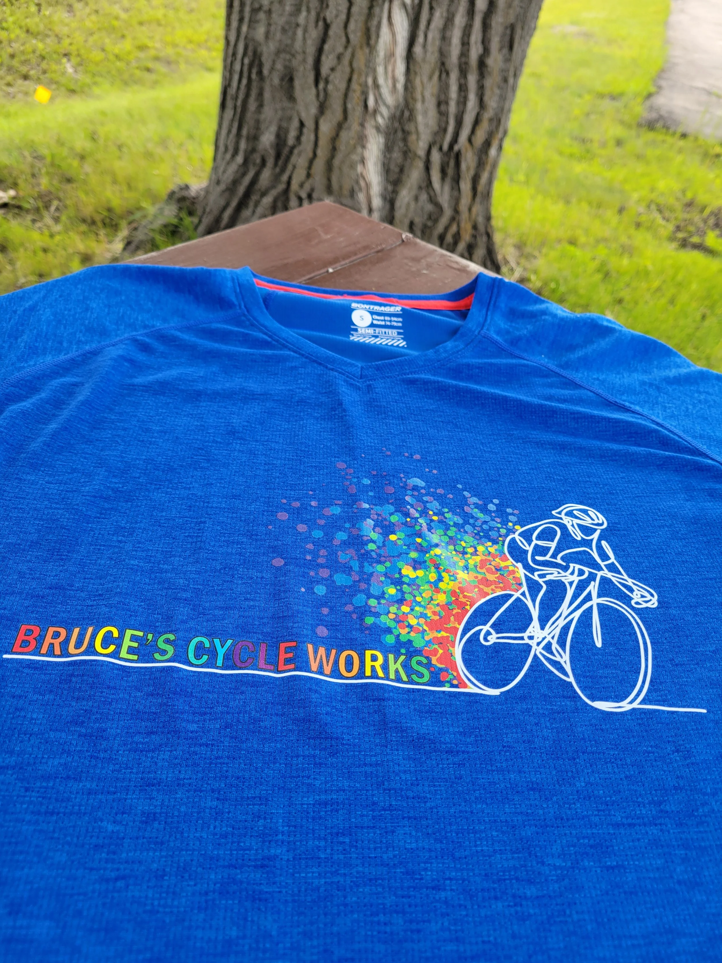 An image of a blue t-shirt with "Bruce's Cycle Works" written on it along with a bicycle illustration.