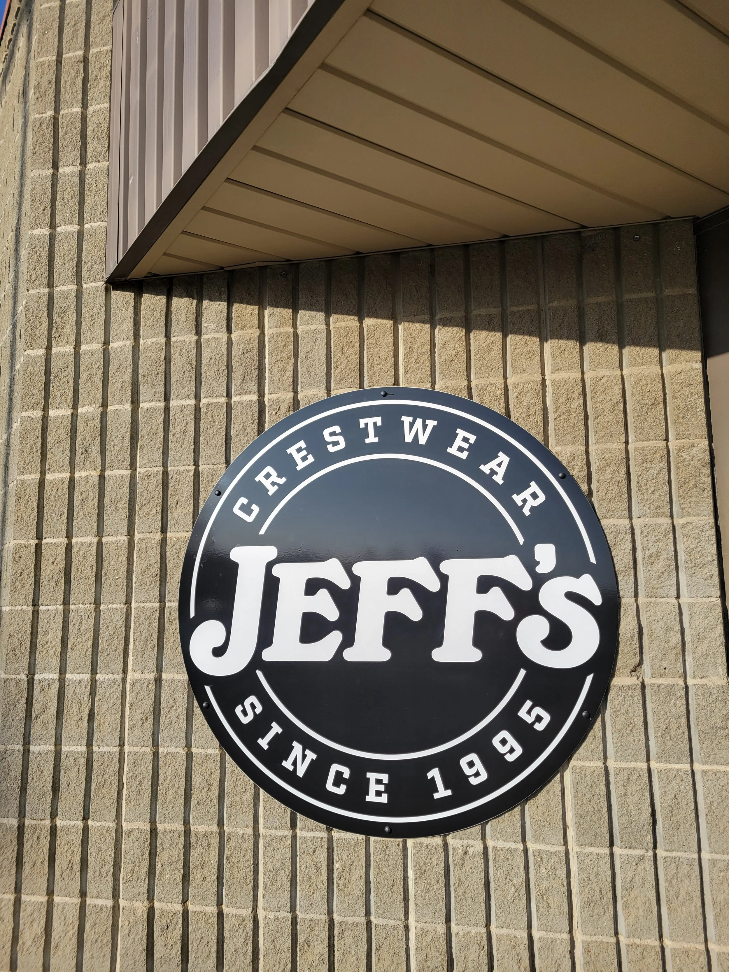 jeffs crestwear logo on the side of a building