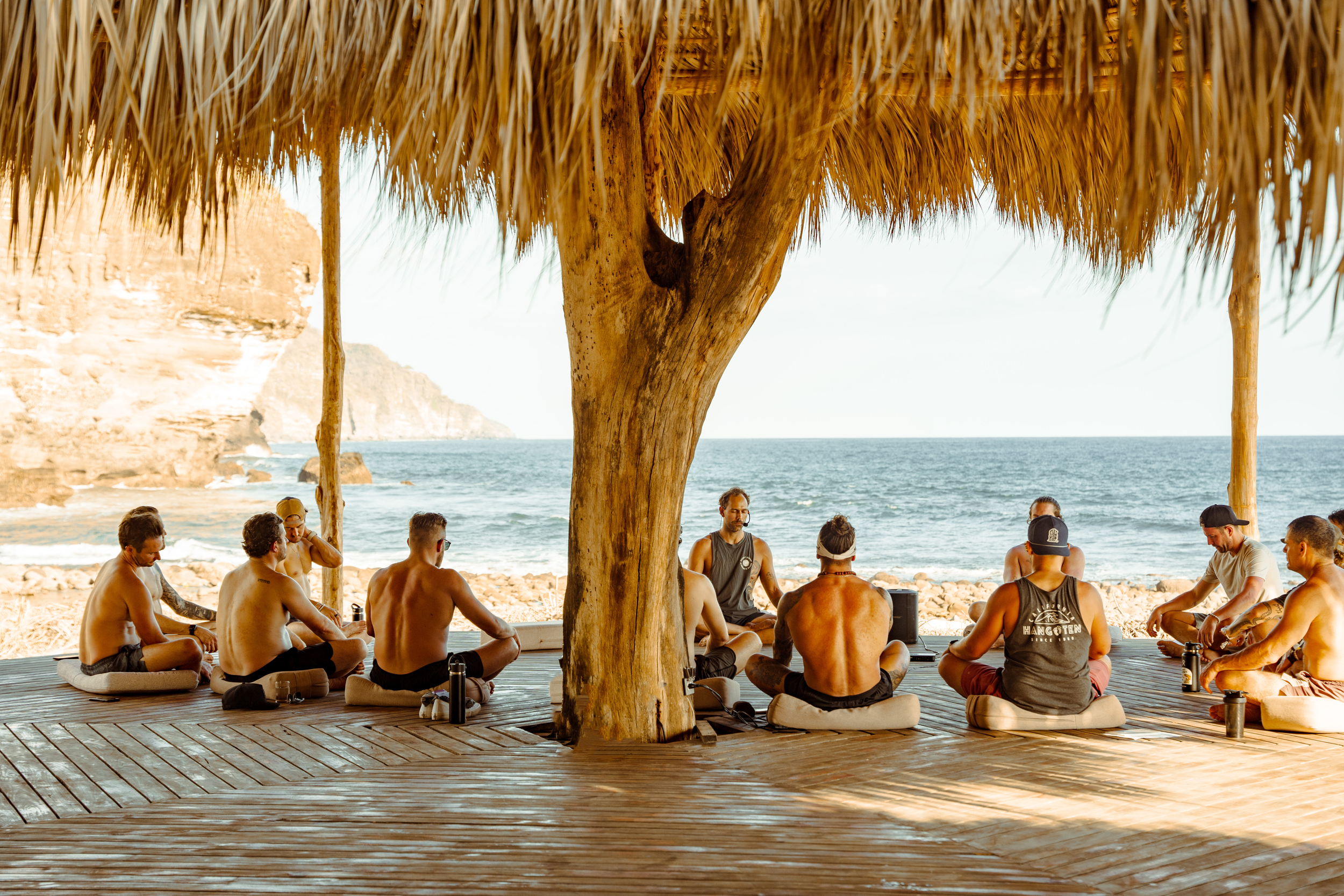 Health optimization retreat participants doing breathwork and meditation by the ocean in Mizata