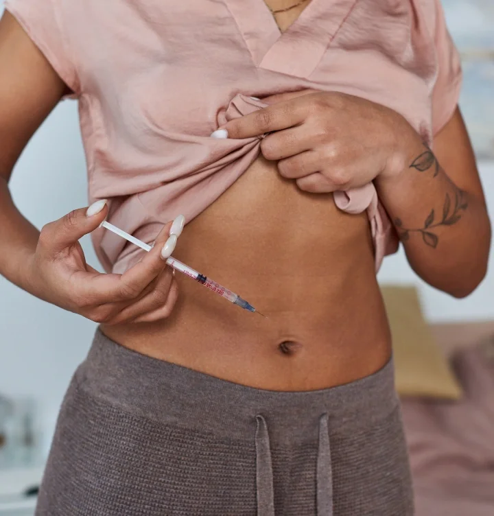 Woman administering a peptide therapy injection in Fort Worth