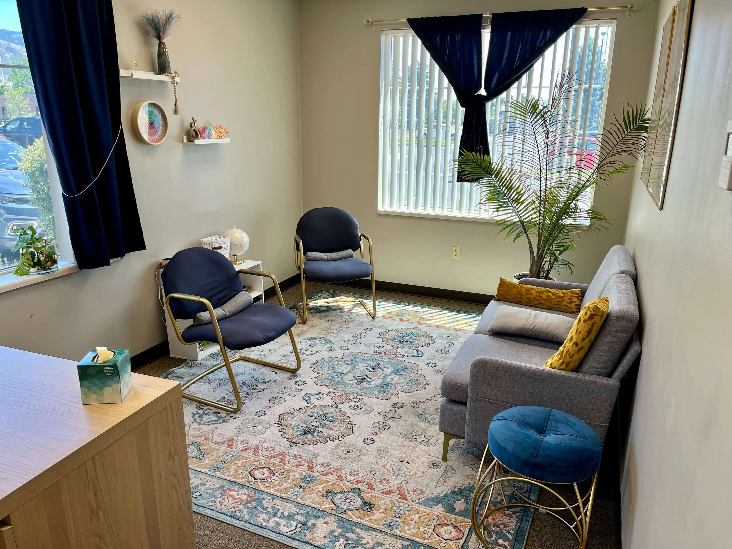 Medical cannabis clinic interior in Logan, Utah with seating area, sofa, chairs, large window, and calming decor.