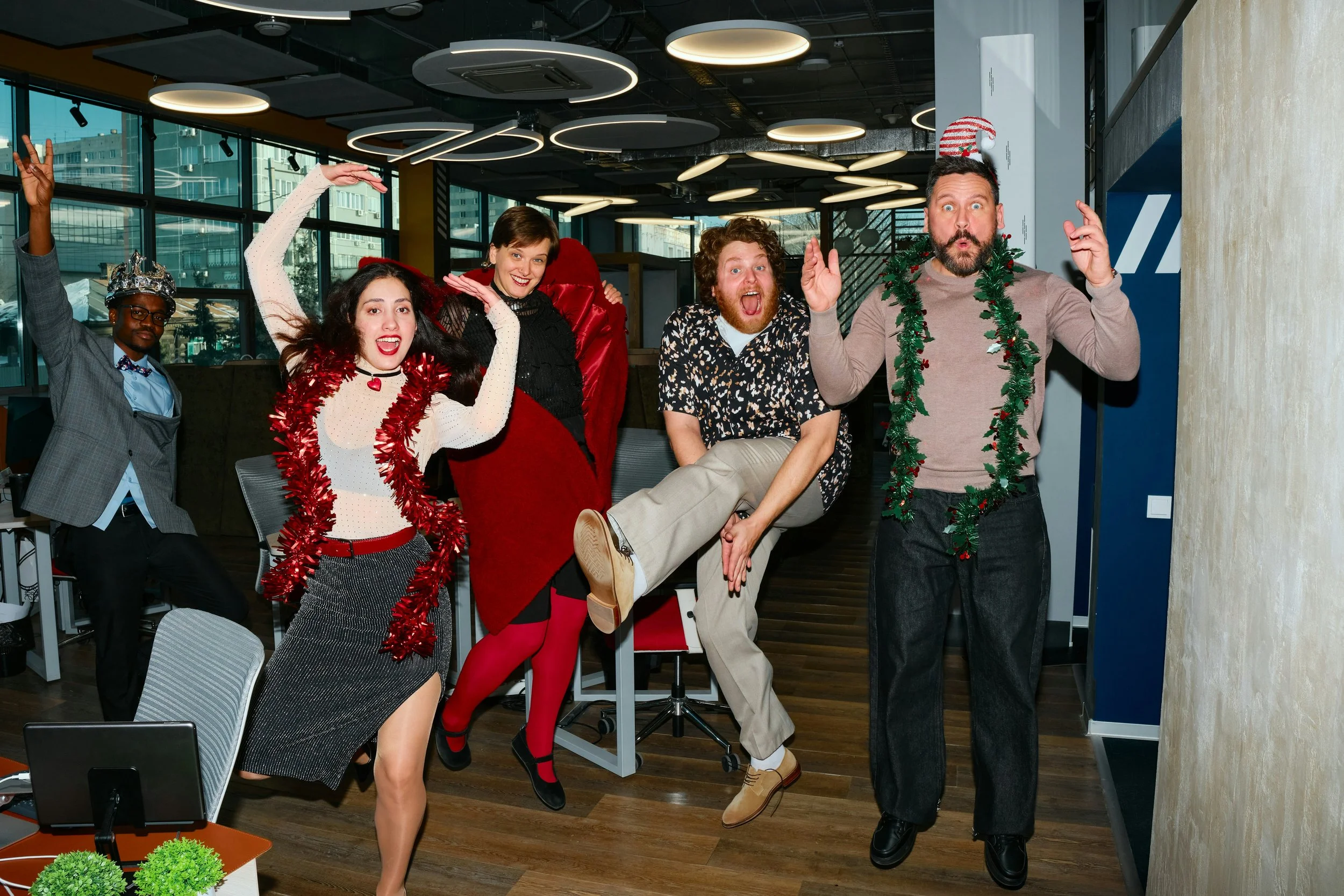 A group of people posing with Christmas decorations, at the office party.