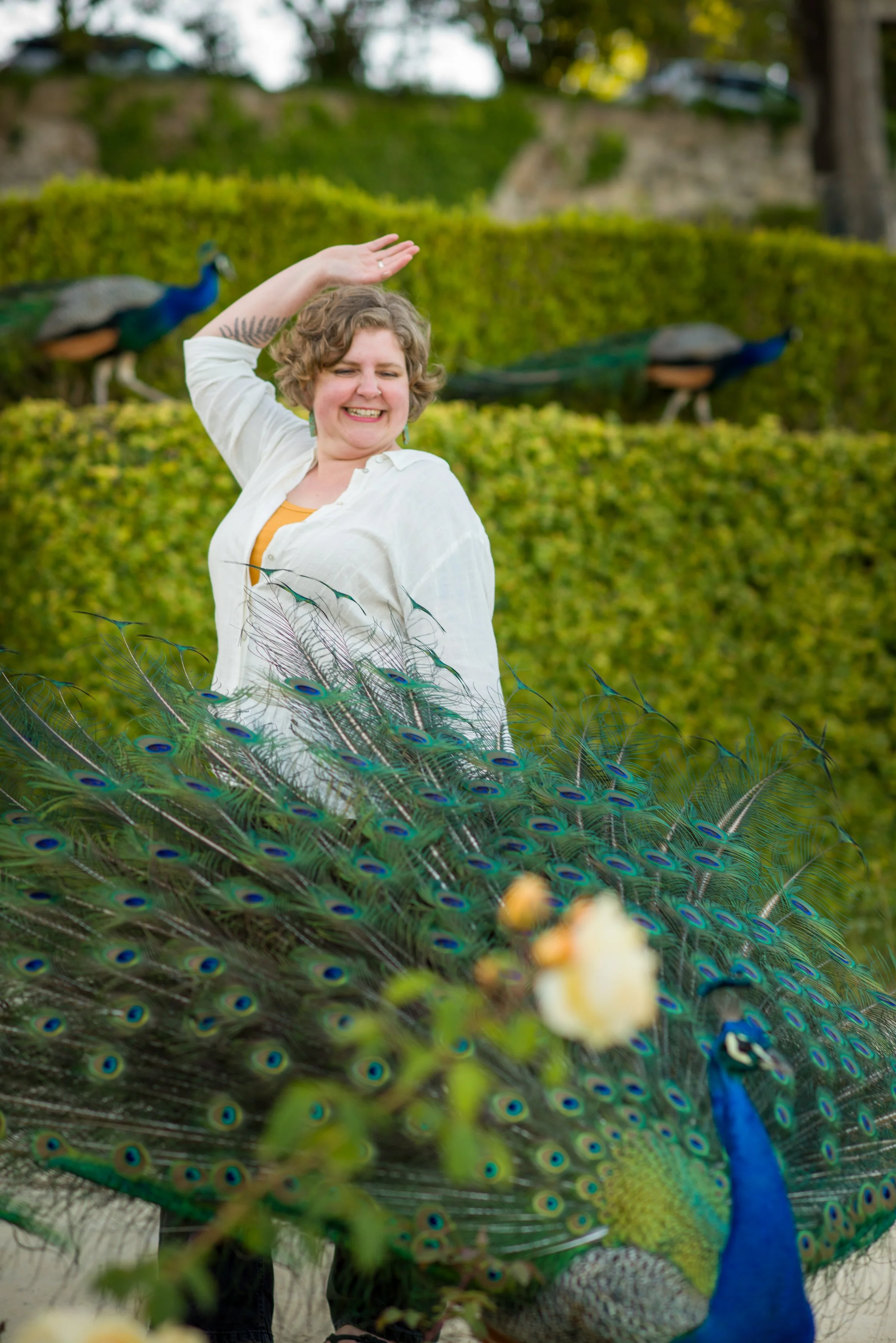 Chelsea Sokolow, LCSW, stands behind a peacock with it's tail open, representing neuroquirky humans.