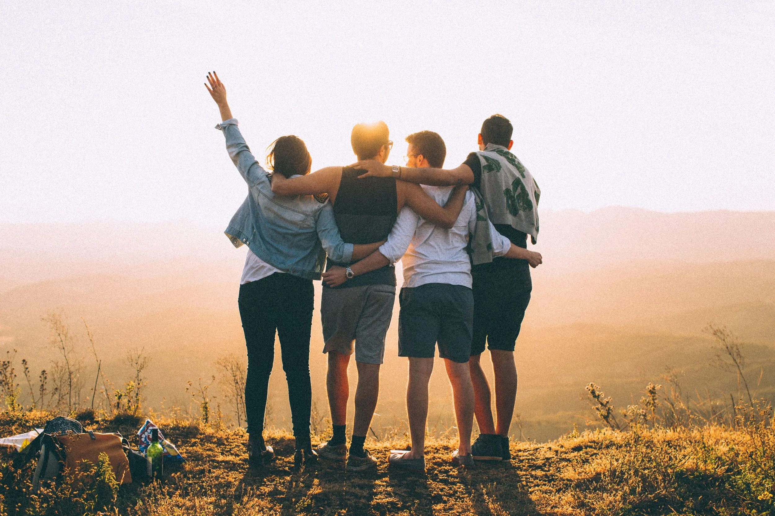 4 adults stand together on a mountain, representing connection, intimacy, and safety in relationships in North Carolina and South Carolina