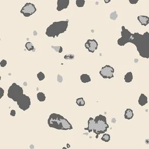 Loose, inky splashes and dots in soft grey and dark grey are scattered across a yellow cream ground, creating an abstract, organic, allover “ink splatter” look that feels modern, airy, and stone-like.