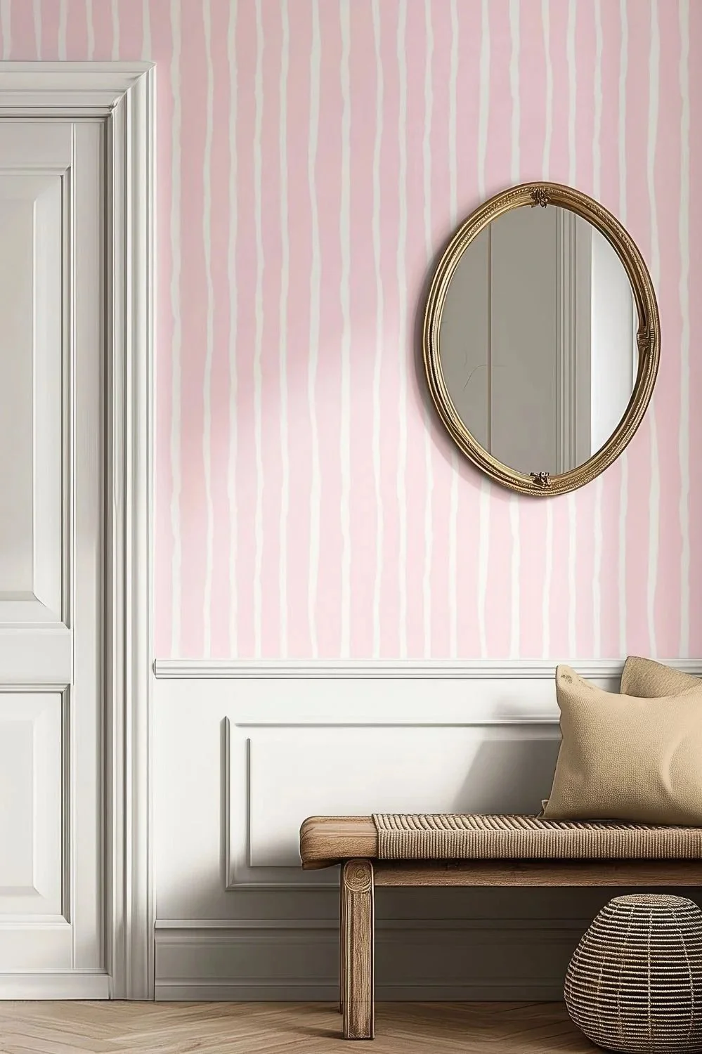 Soft pink and cream wavy striped wallpaper in a cozy entryway setting with a wooden bench, beige pillows, and an antique oval mirror.