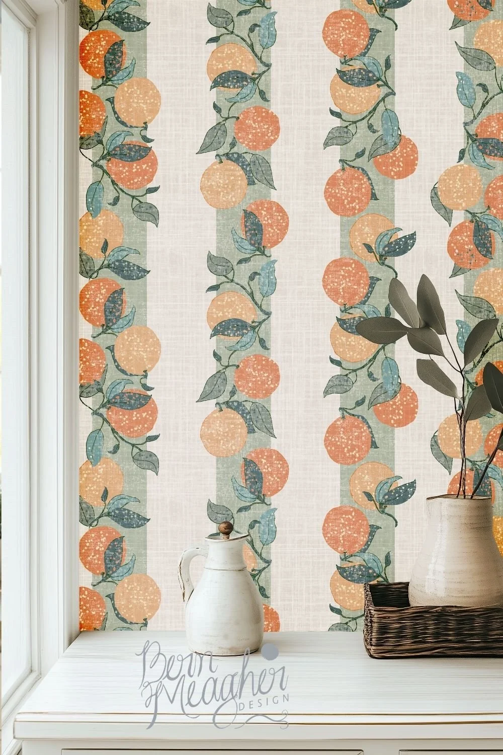 Farmhouse-style wallpaper in warm muted oranges and sage greens with textured vertical stripes featuring citrus fruit and leafy branches, shown in a bright kitchen nook with white cabinetry and ceramic vases on a white wooden countertop.