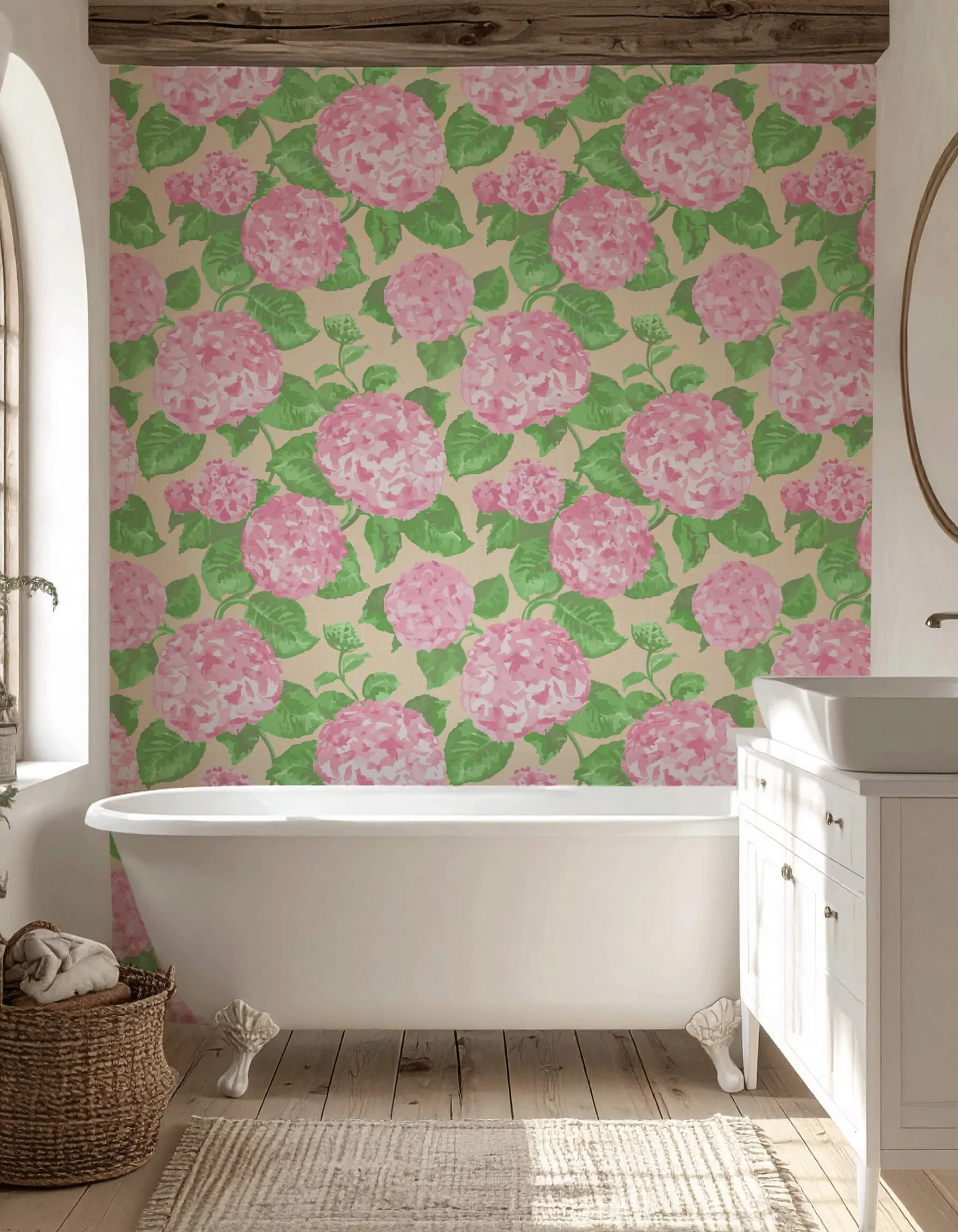 A farmhouse bathroom with a floral wallpaper featuring pink hydrangea flowers and green leaves, a white clawfoot bathtub, a white vanity with a sink, a woven basket, and a window with a small plant on the sill.