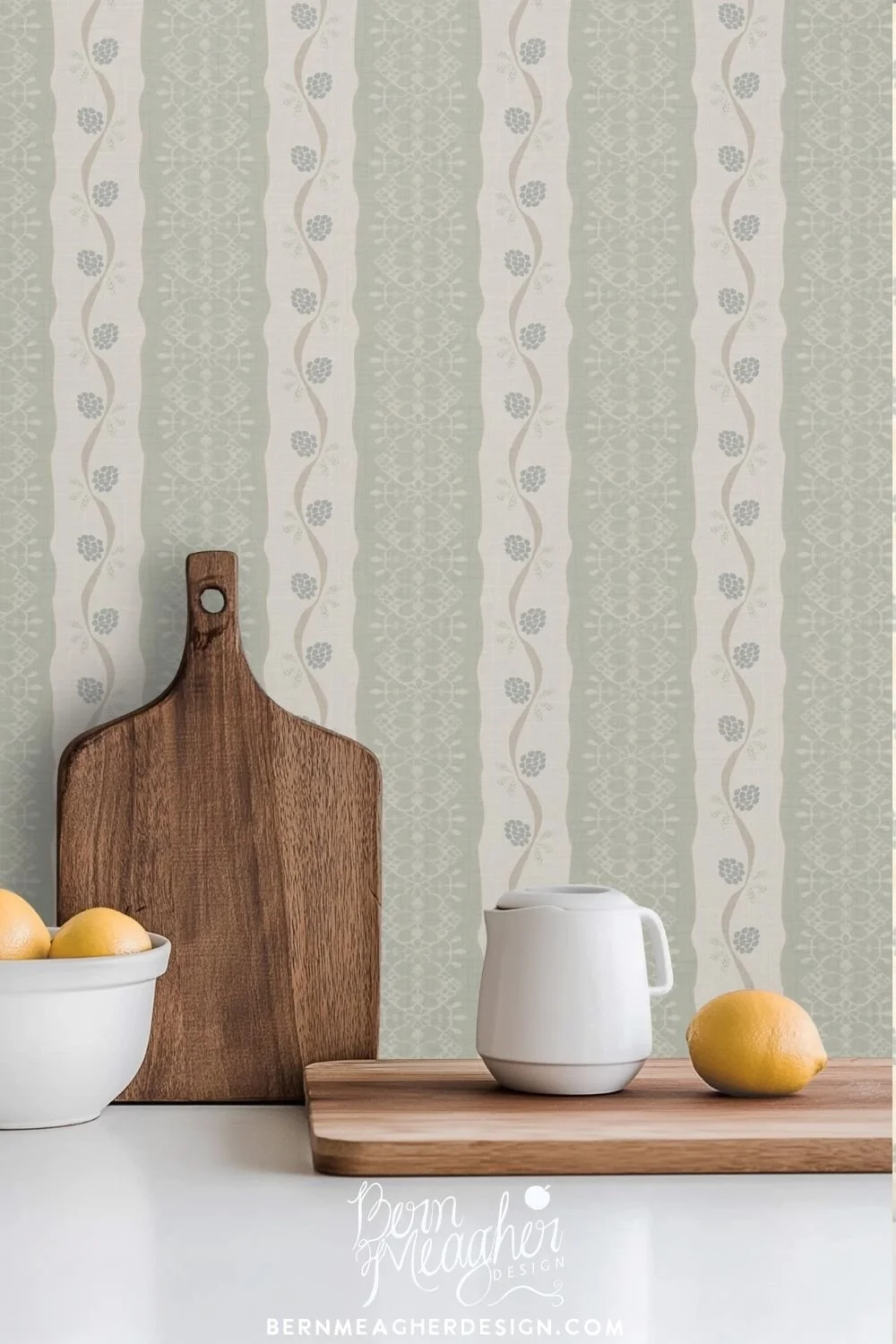 Peel and stick wallpaper featuring vintage inspired soft sage and cream vertical stripes with delicate berry botanical and lace patterns, styled in a kitchen setting with white ceramic bowls, wooden utensils, and cutting boards on a white countertop.