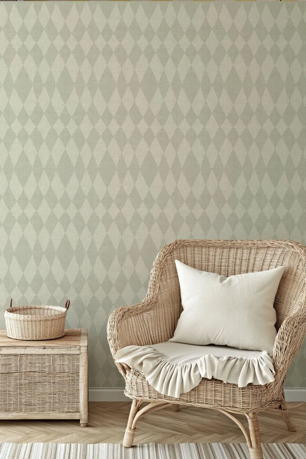 Textured peel & stick wallpaper with a subtle harlequin diamond pattern in sage green, styled in a cozy corner featuring natural woven furniture, a cream pillow, and a soft throw.