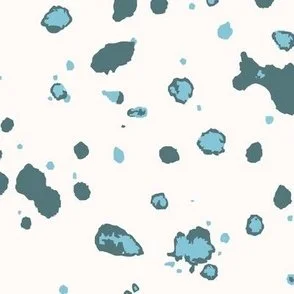 Loose, inky splashes and dots in muted teal and soft blue are scattered across a warm cream ground, creating an abstract, organic, allover “ink splatter” look that feels modern, airy, and stone-like.