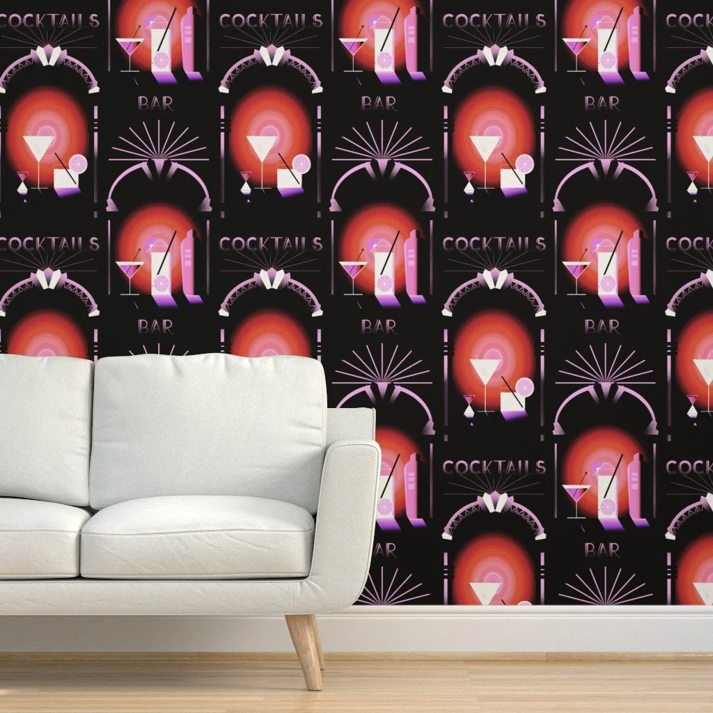 Dark wallpaper with pink and coral Art Deco style cocktail illustrations and radiant sunburst patterns, styled in a modern lounge setting with a white sofa and light wood floor.